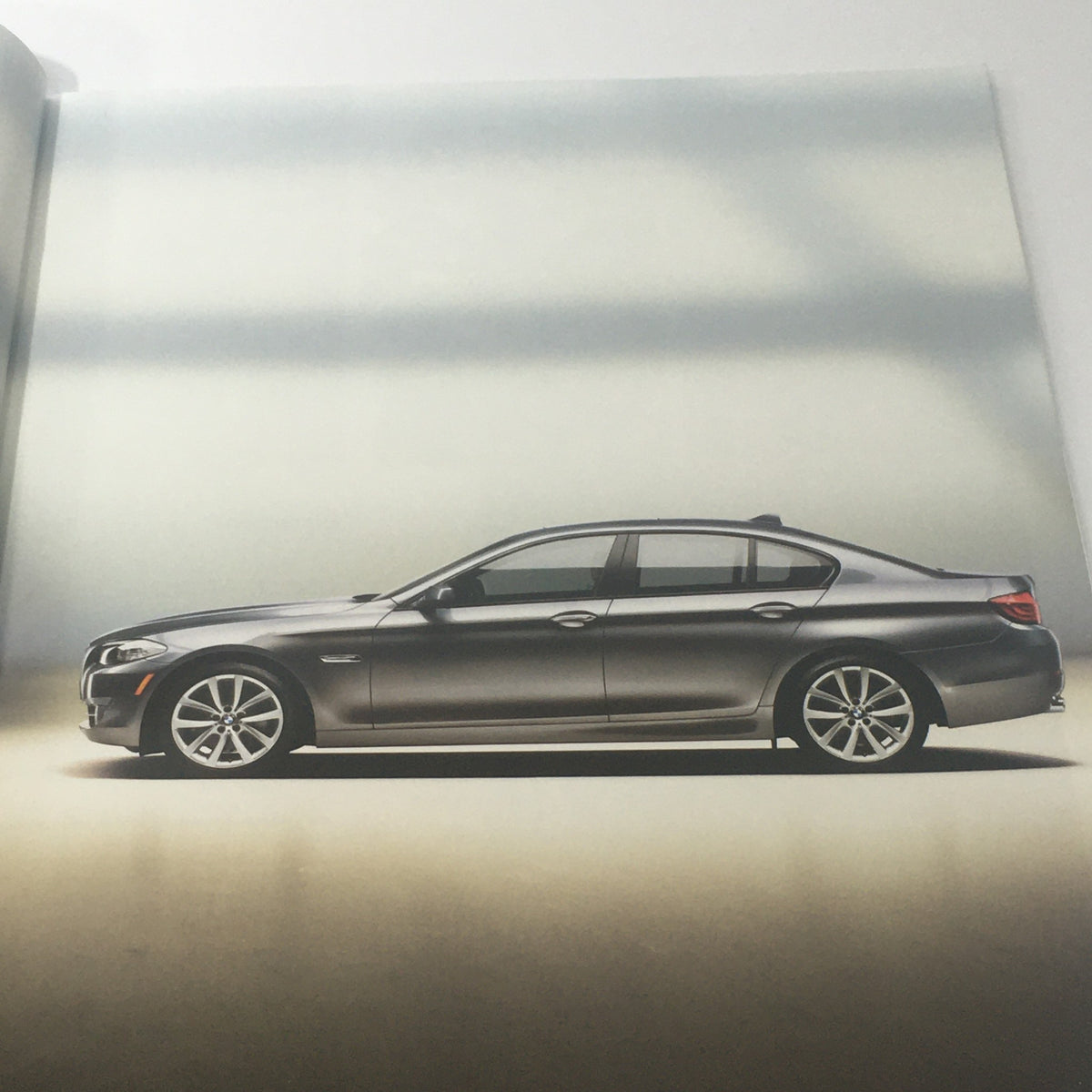 2011 BMW 5 Series Sedan 528i 535i 550i X-D Dealership Car Auto Brochure Catalog showcasing a side view of a sleek gray BMW 5 Series sedan.