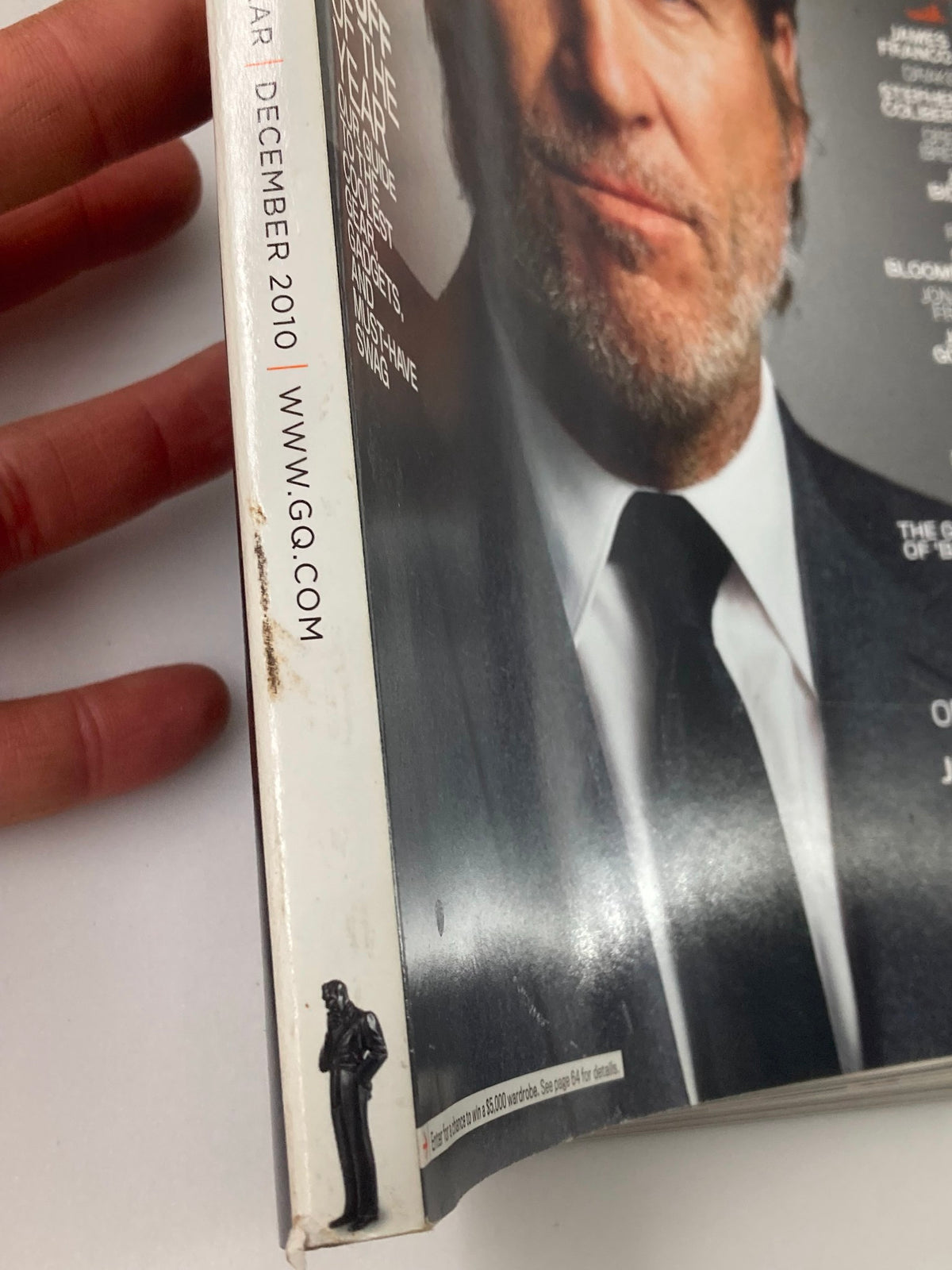 Close-up of the spine of GQ Magazine December 2010 showing minor wear, highlighting the vintage condition of this collectible issue.