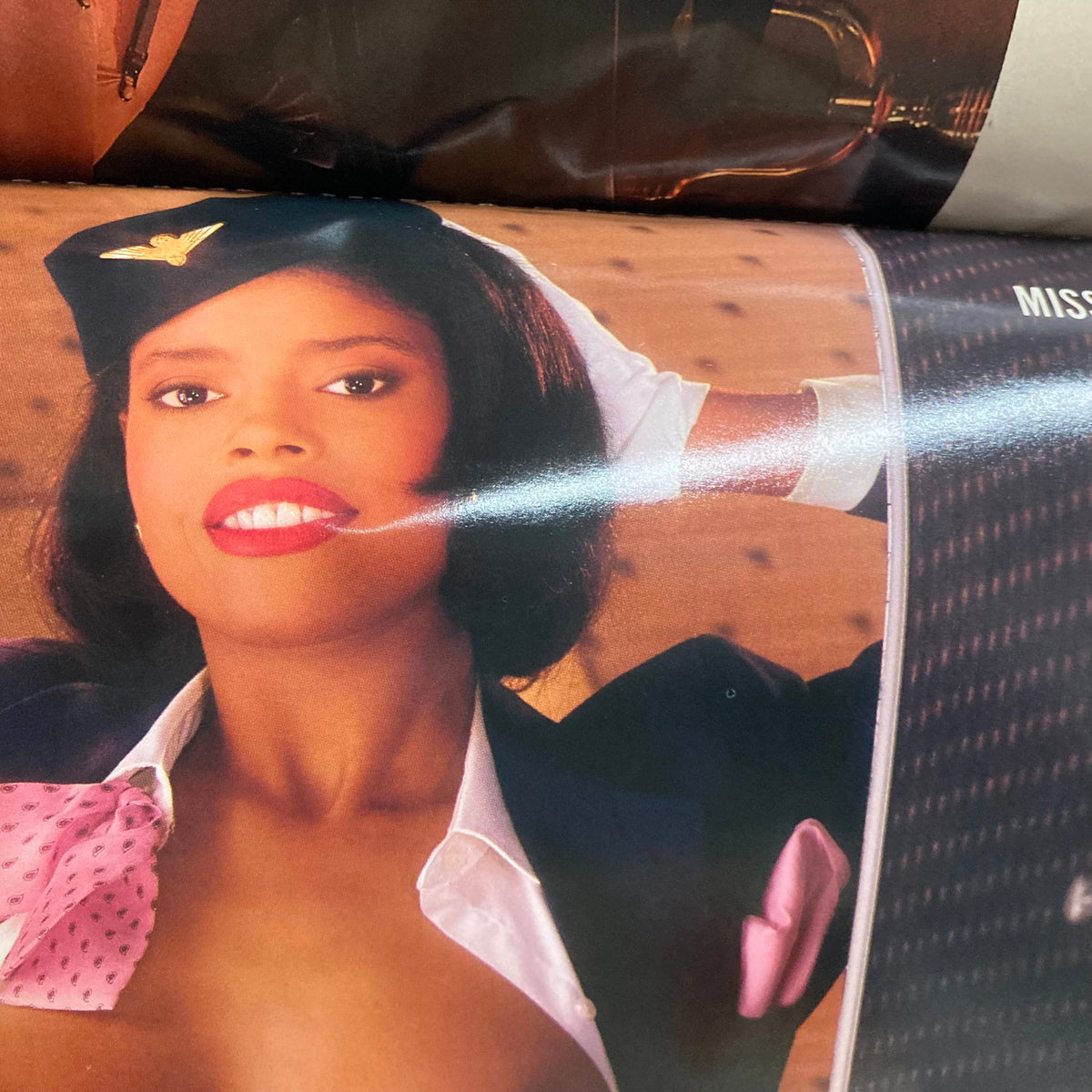 Inside page from VTG Playboy Magazine November 1990, featuring a model in airline attire, representing the magazine's engaging visual content.
