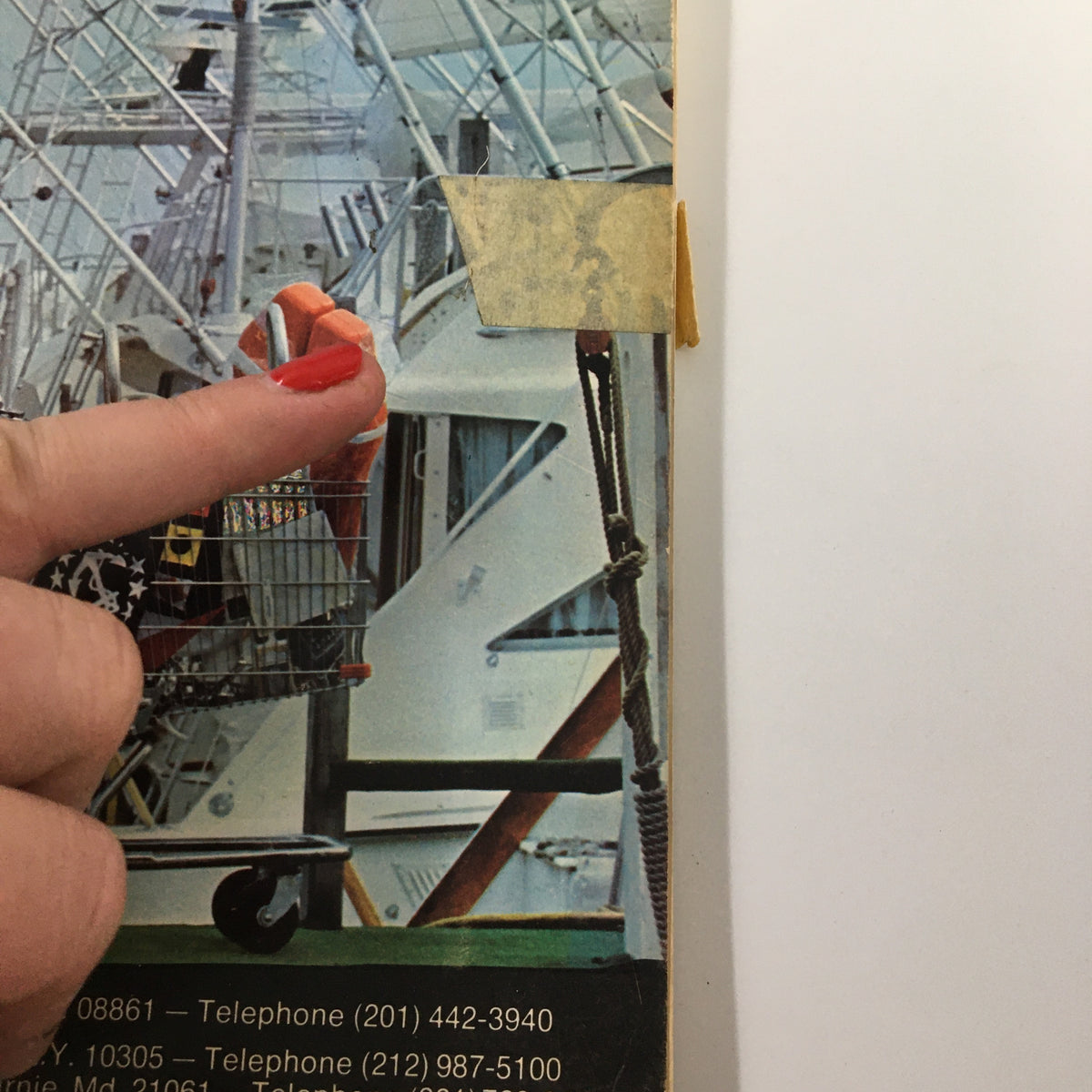 Close-up image of the VTG 1973 E&B Marine Supply A Complete Marine Buyers Guide Catalog cover, highlighting a finger pointing at an orange life preserver.
