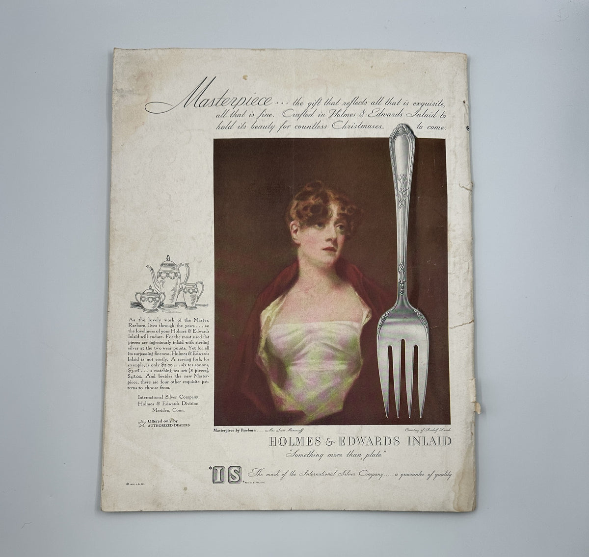 Artistic advertisement showcasing a portrait of a woman alongside a fork, promoting Holmes & Edwards Inlaid flatware, from the Woman’s Home Companion Magazine December 1932 Christmas Cover Stories.