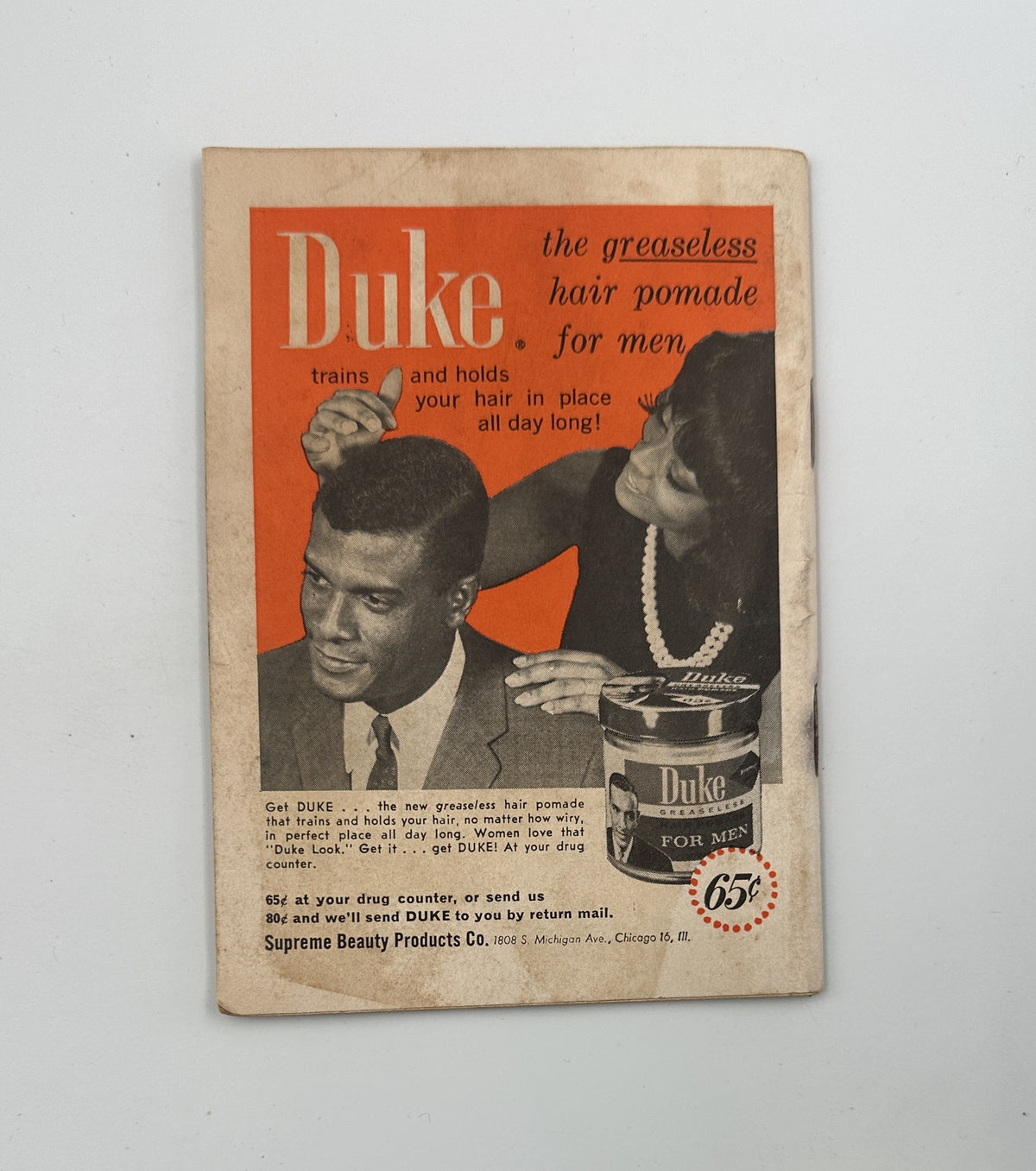 Jet Magazine January 14, 1965 advertisement for Duke greaseless hair pomade for men, showcasing a hair styling demonstration by a woman on a man.