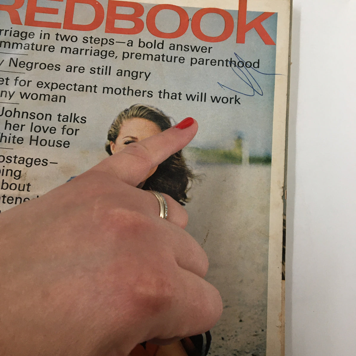 Close-up of VTG Redbook Magazine July 1966 cover highlighting articles on marriage and parenting, with a finger pointing to the text.
