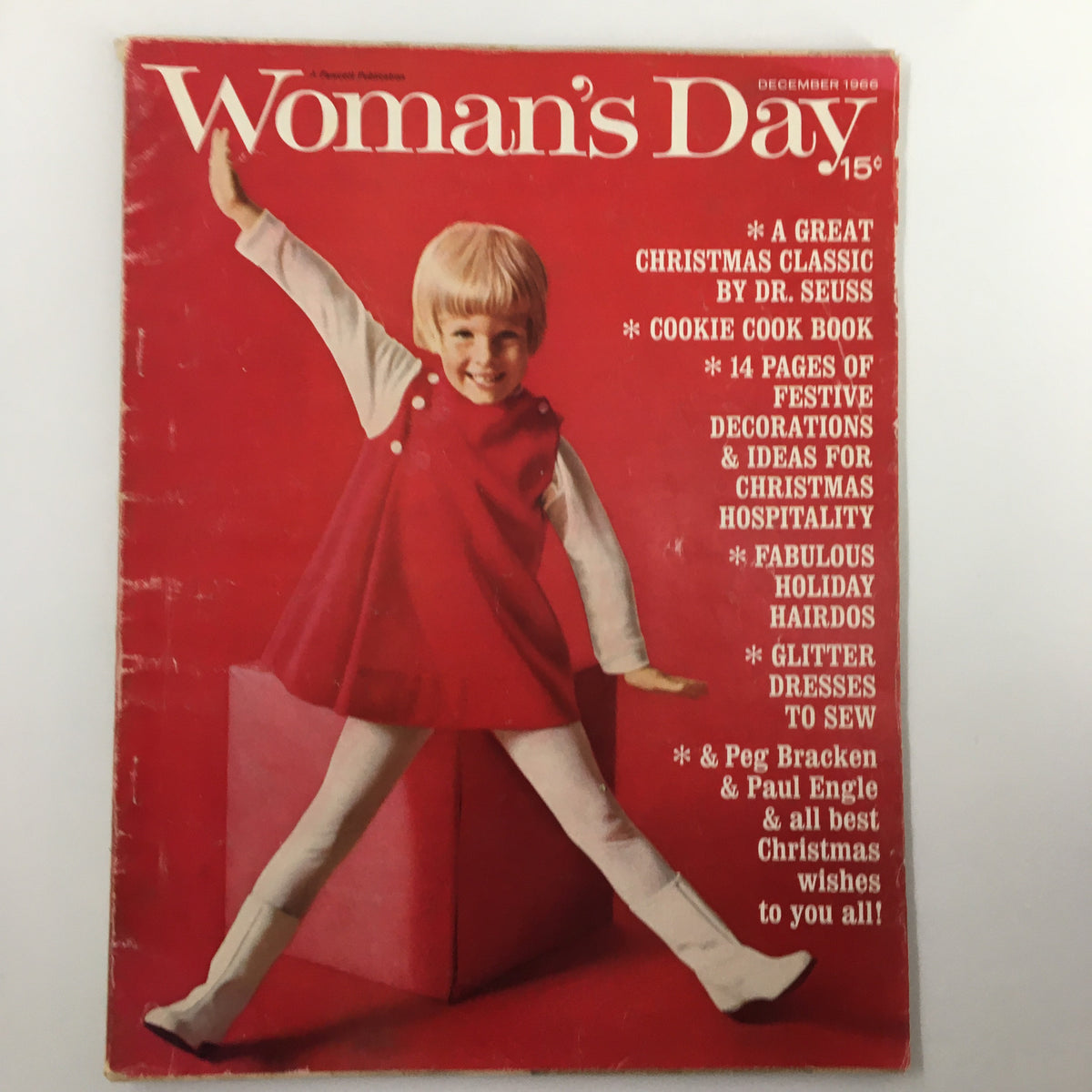 Cover of VTG Woman's Day Magazine December 1966 featuring a girl in a red dress and white tights, celebrating Christmas with content related to Dr. Seuss.