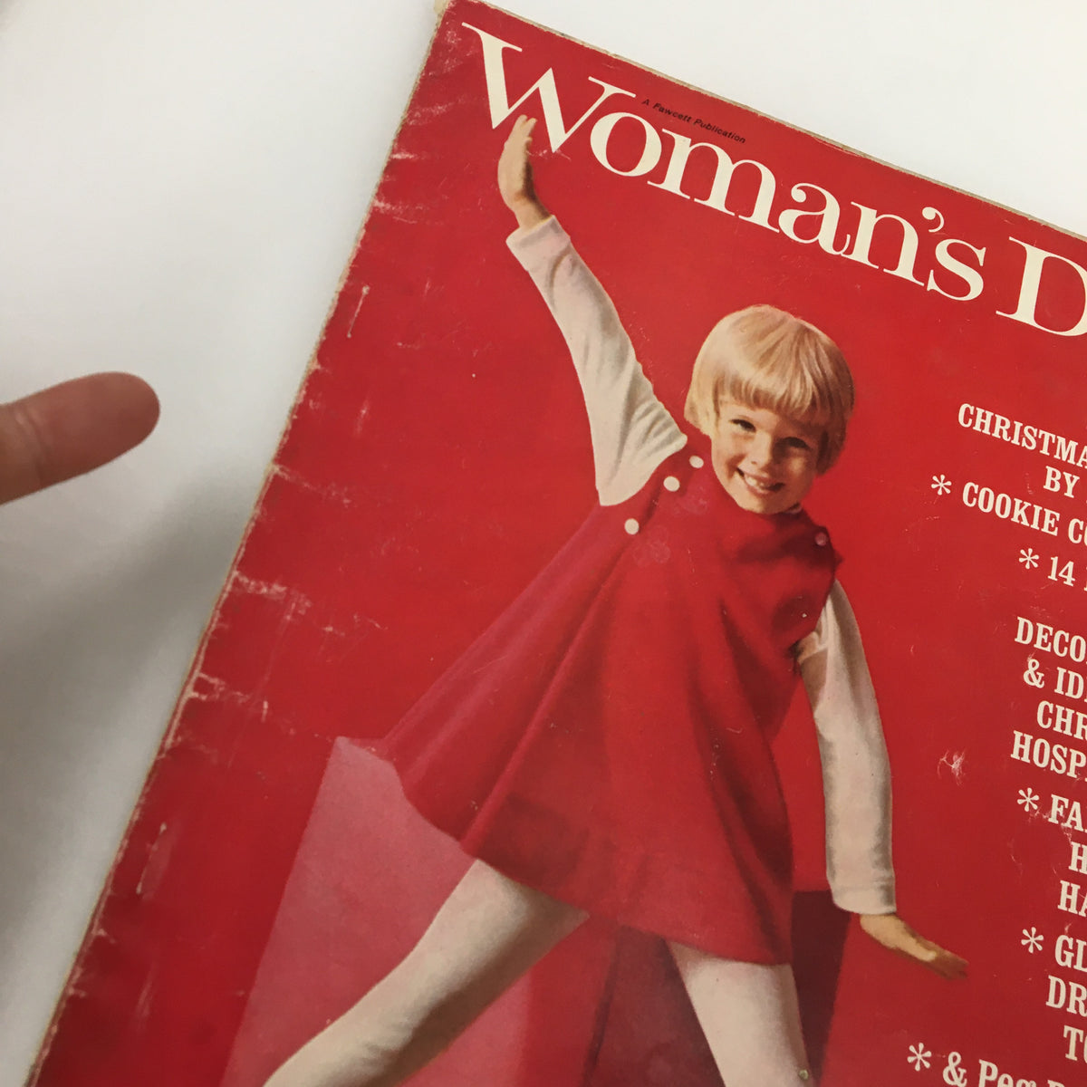 Close-up of the cover of VTG Woman's Day Magazine December 1966, highlighting the festive design and a girl joyfully posing, emphasizing Christmas themes by Dr. Seuss.