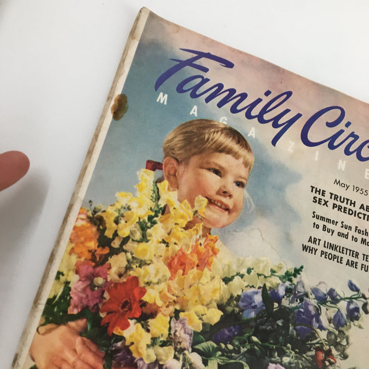 Close-up of the cover of VTG Family Circle Magazine May 1955, highlighting the young girl and vibrant flowers, representing summer fashion inspiration.