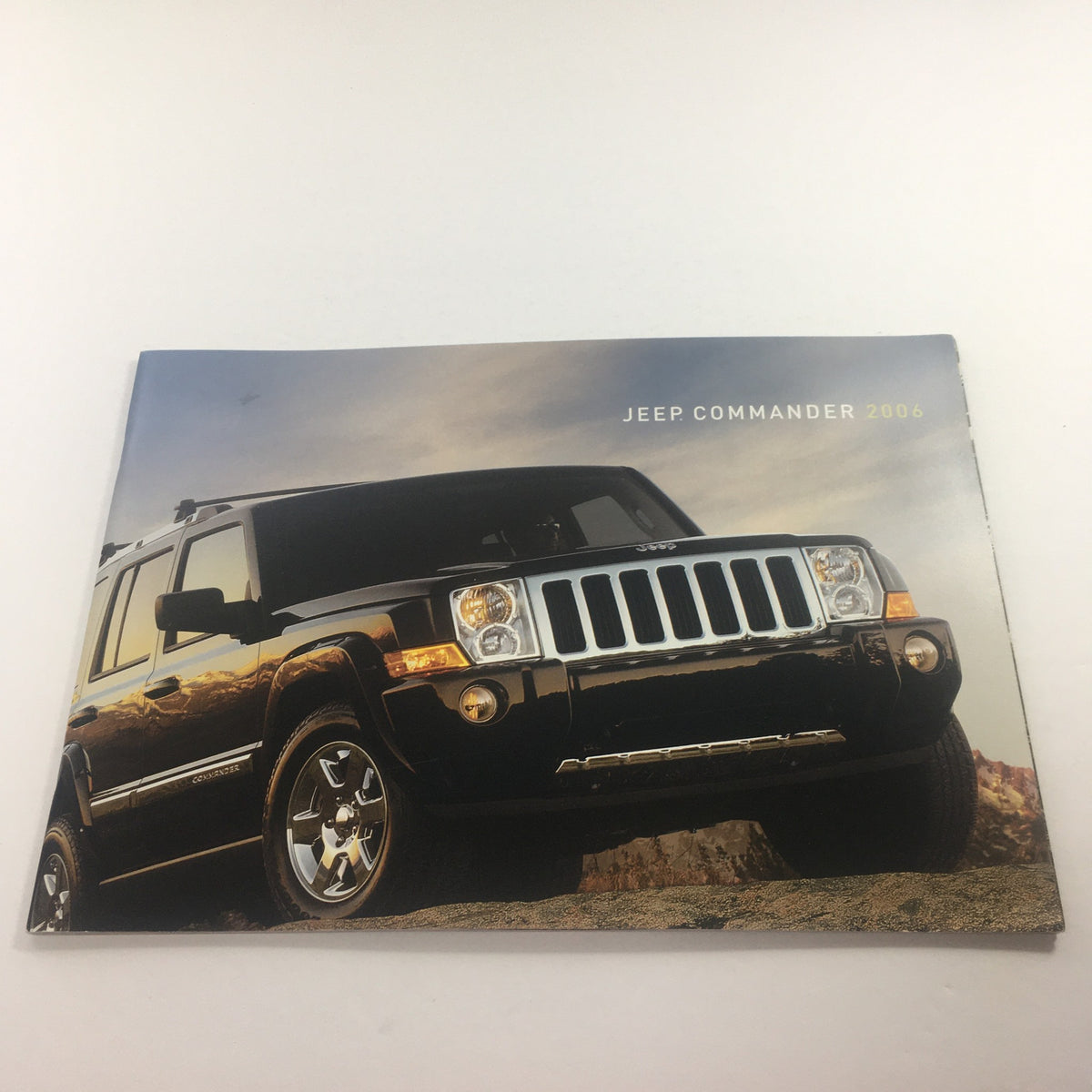 2006 Jeep Commander Dealership Car Auto Brochure Catalog featuring a sleek black Jeep Commander in natural lighting, showcasing its rugged design and stylish appearance.