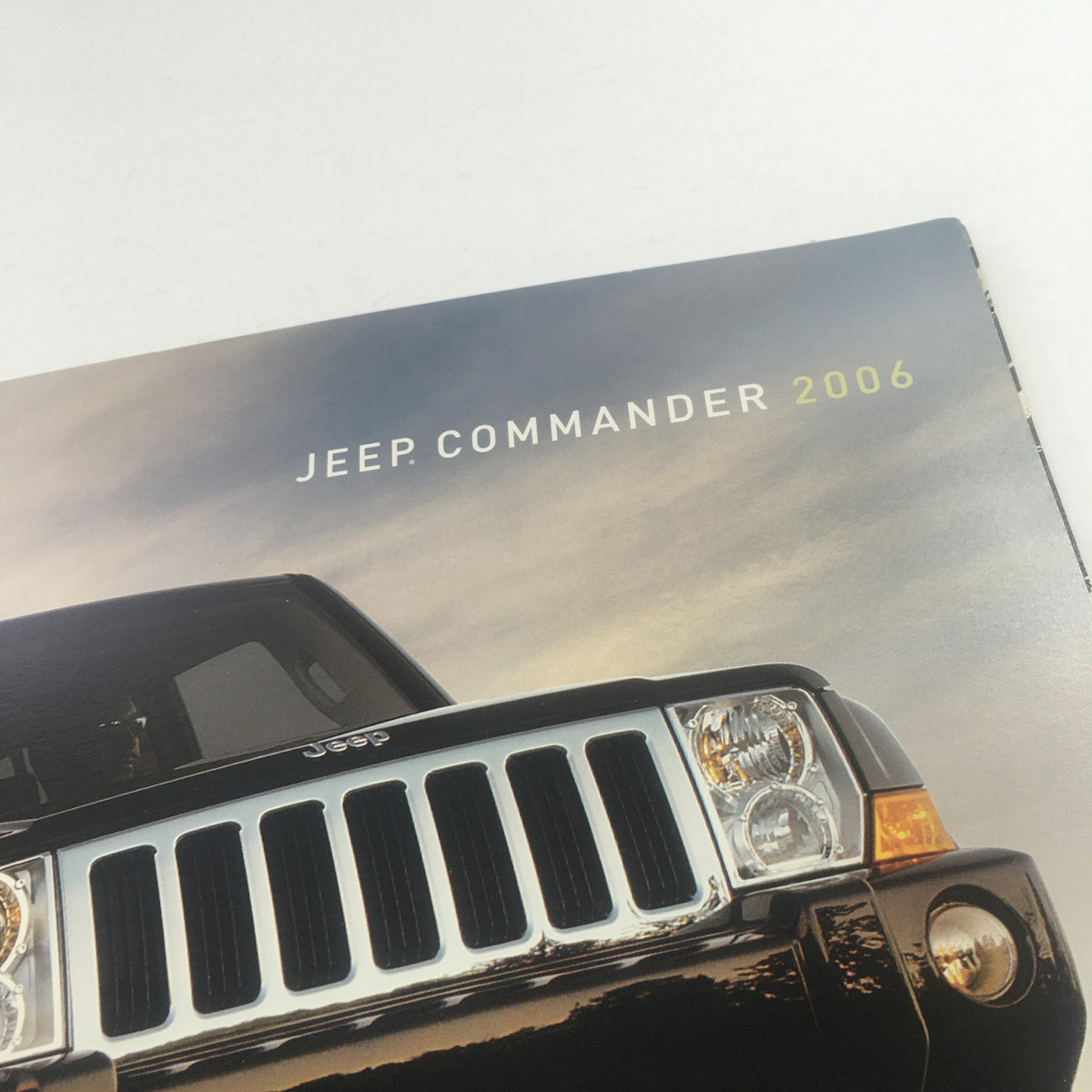 Close-up of the 2006 Jeep Commander Dealership Car Auto Brochure Catalog cover, highlighting the Jeep Commander text and sleek black vehicle against a dramatic sky.