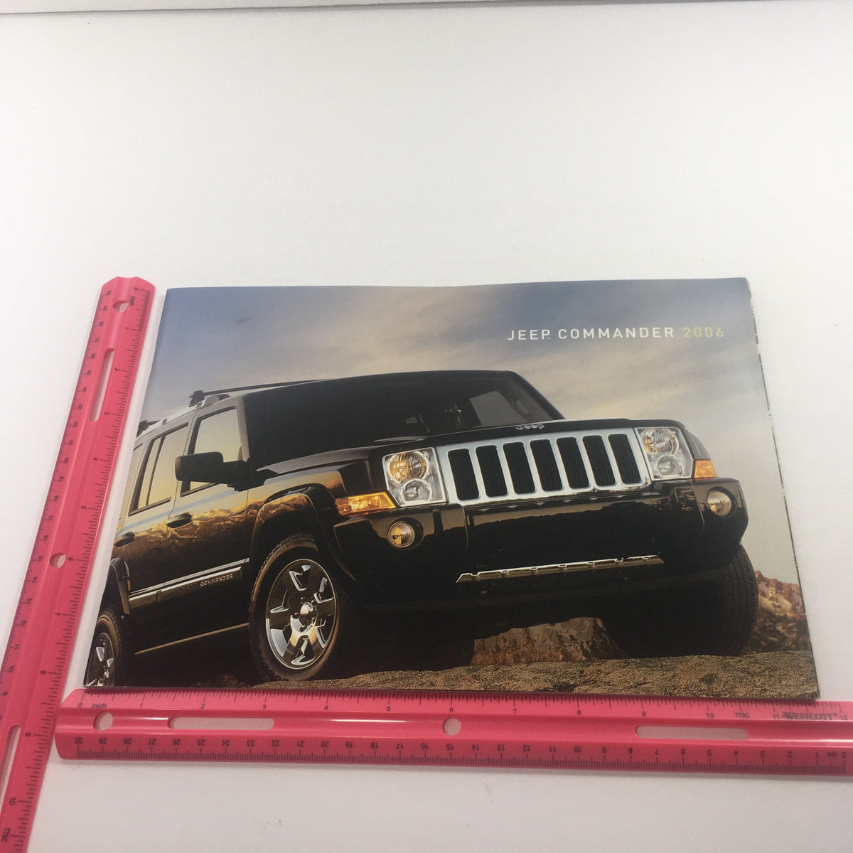 2006 Jeep Commander dealership car auto brochure catalog cover showcasing a black Jeep Commander with a scenic background, perfect for vintage car enthusiasts and collectors.