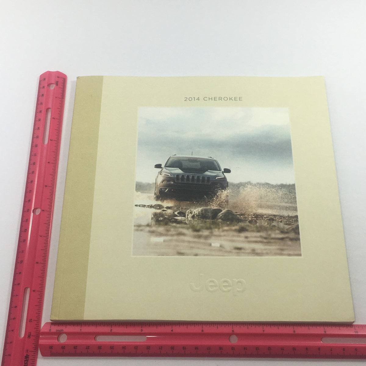 2014 Jeep Cherokee SUV Dealership Car Auto Brochure Catalog with a striking image of the vehicle driving through water, highlighting its adventurous spirit.