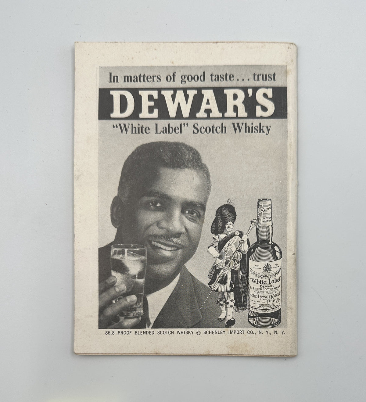 Advertisement for Dewar's White Label Scotch Whisky from Jet Magazine February 15, 1962, featuring a smiling man holding a drink, exemplifying 1960s advertising style.