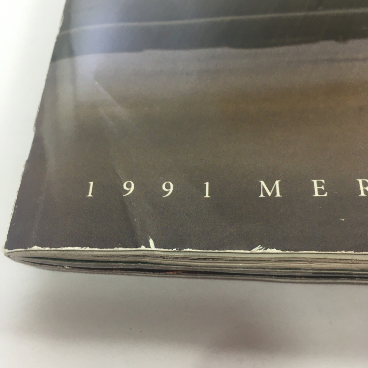 Close-up of the cover of the 1991 Mercedes-Benz S-Class 300 SE-Sedan Dealership Car Auto Brochure Catalog showing the title and age-related wear.