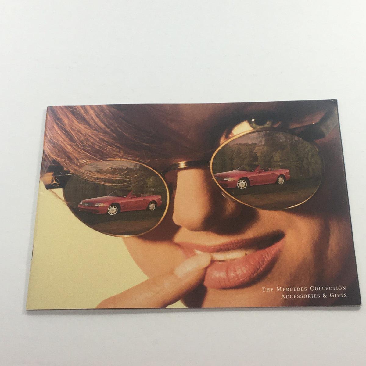 1994 Mercedes-Benz Collection Accessories Dealership Car Auto Brochure Catalog cover featuring a model with stylish sunglasses reflecting a red Mercedes-Benz vehicle.