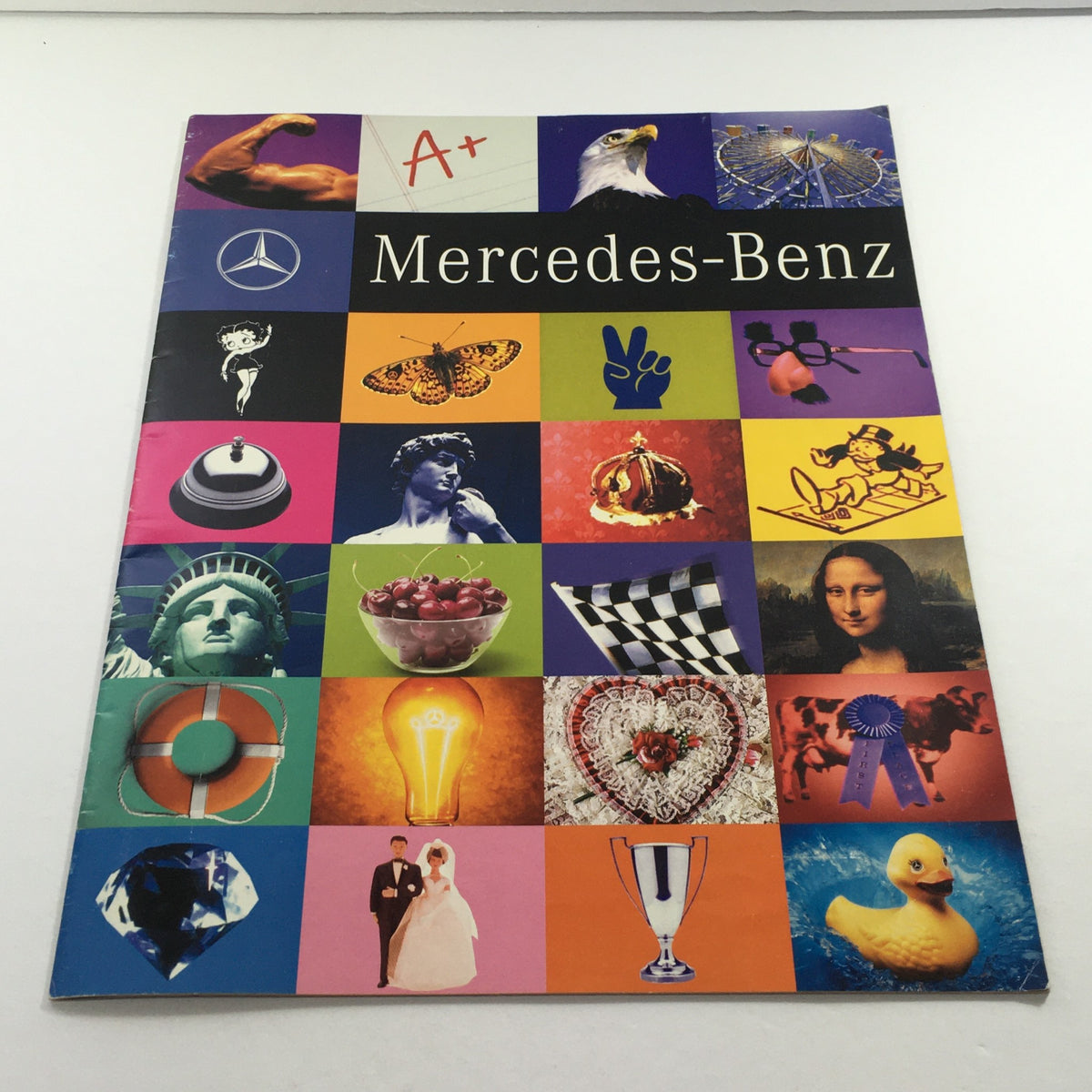 1998 Mercedes-Benz Two-Lane Blacktop Dealership Car Auto Brochure Catalog featuring a colorful collage of images including the Mercedes-Benz logo and other iconic symbols.
