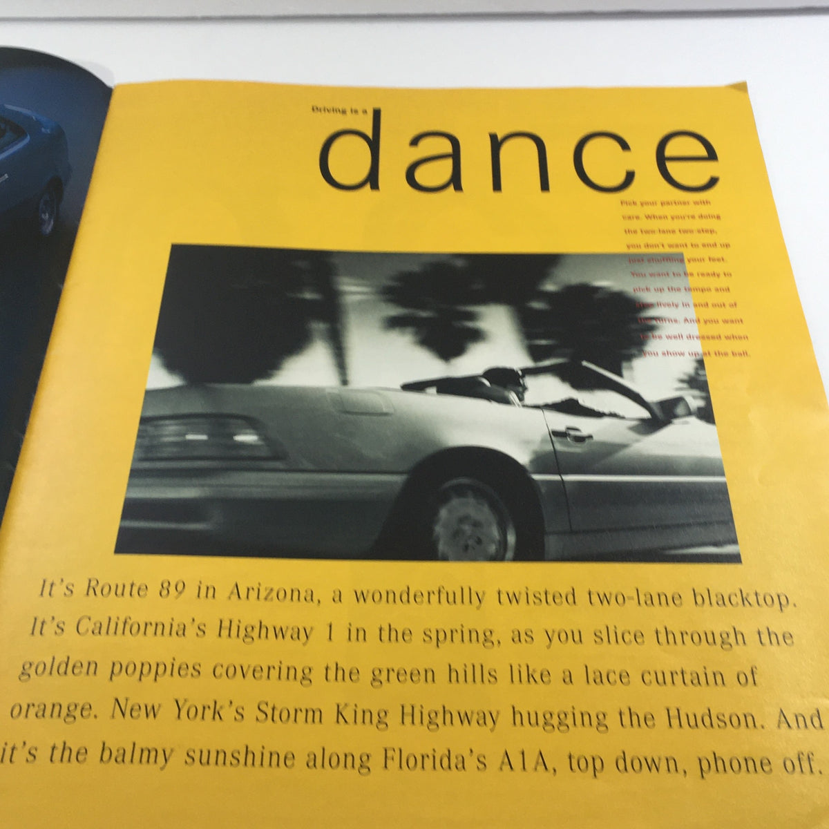 Interior page from the 1998 Mercedes-Benz Two-Lane Blacktop Dealership Car Auto Brochure Catalog showcasing a stylized image of a car in motion against a vibrant yellow background.