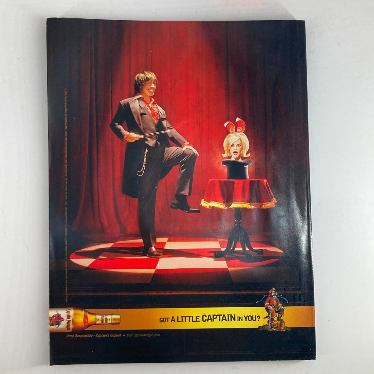 Back cover of Sports Illustrated Magazine Winter 2004, featuring a theatrical advertisement with a magician and a model, adding a unique artistic element to the swimsuit issue.