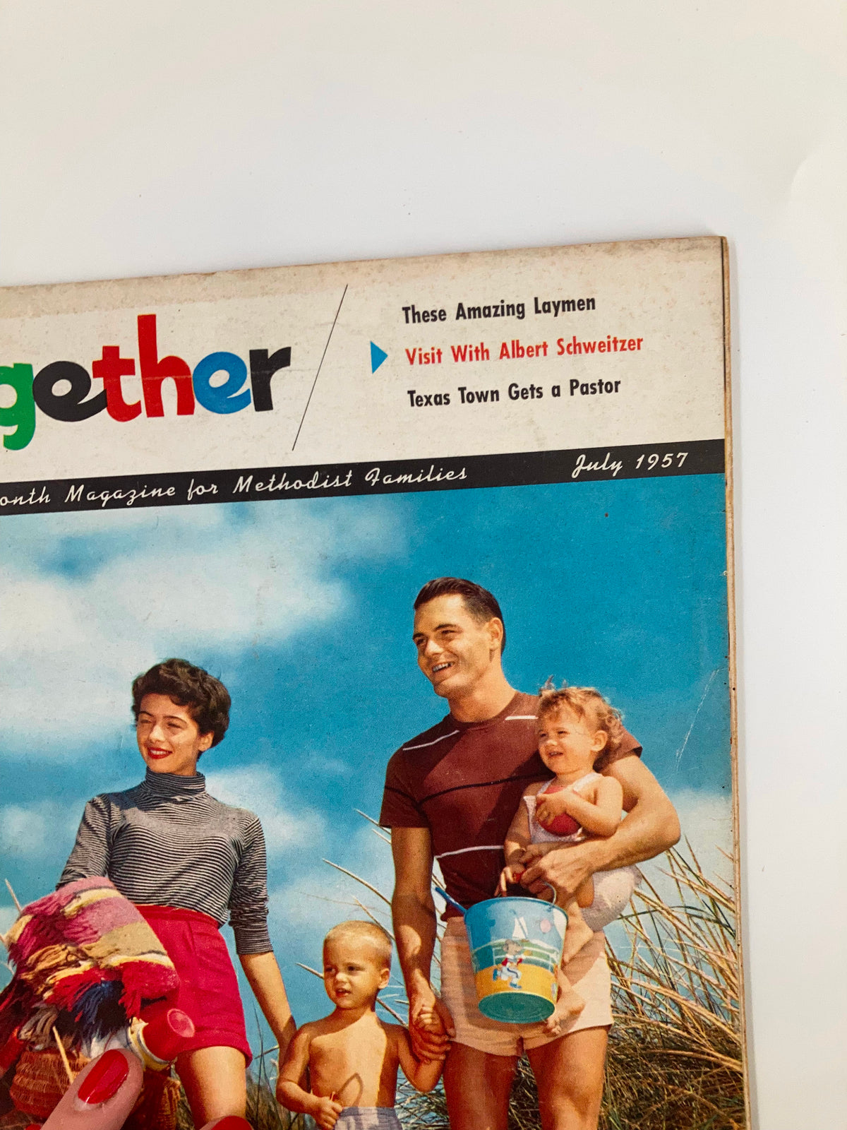 Close-up of the cover of VTG Together Magazine July 15 1957 featuring a family enjoying time by the beach, emphasizing community and family connections.