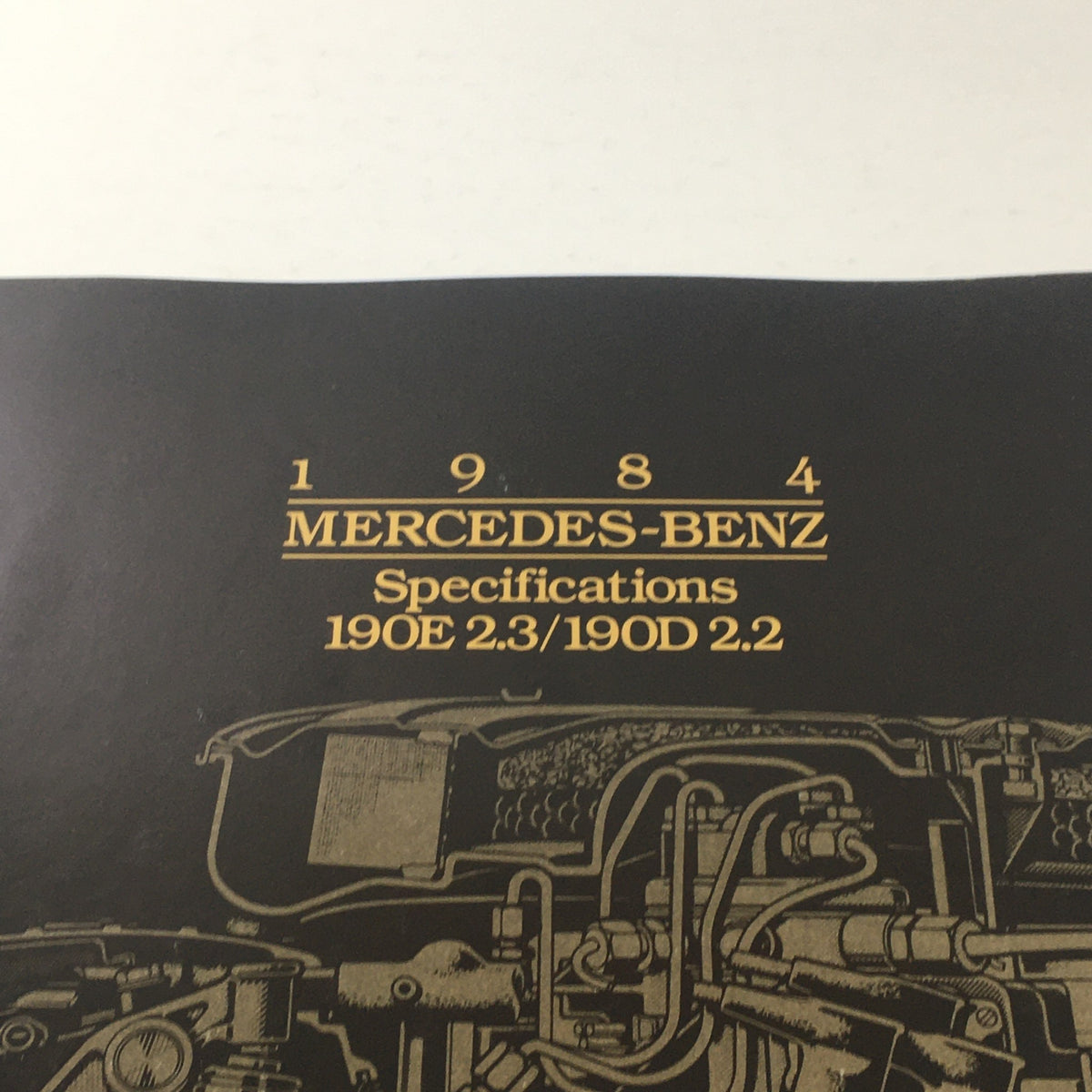 Close-up view of the 1984 Mercedes-Benz 190E 2.3/190D 2.2 Dealership Car Auto Brochure title and specifications.