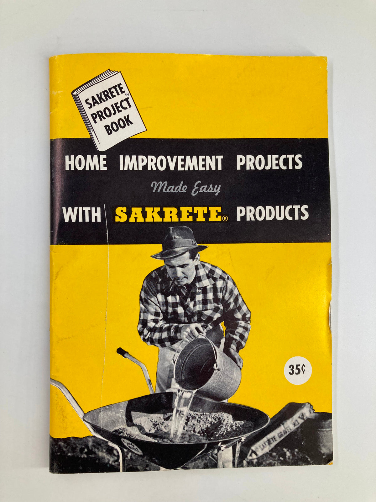 VTG Sakrete Project Book 1950 Home Improvement Projects cover featuring a man using Sakrete products with a wheelbarrow, showcasing vintage DIY home improvement ideas.