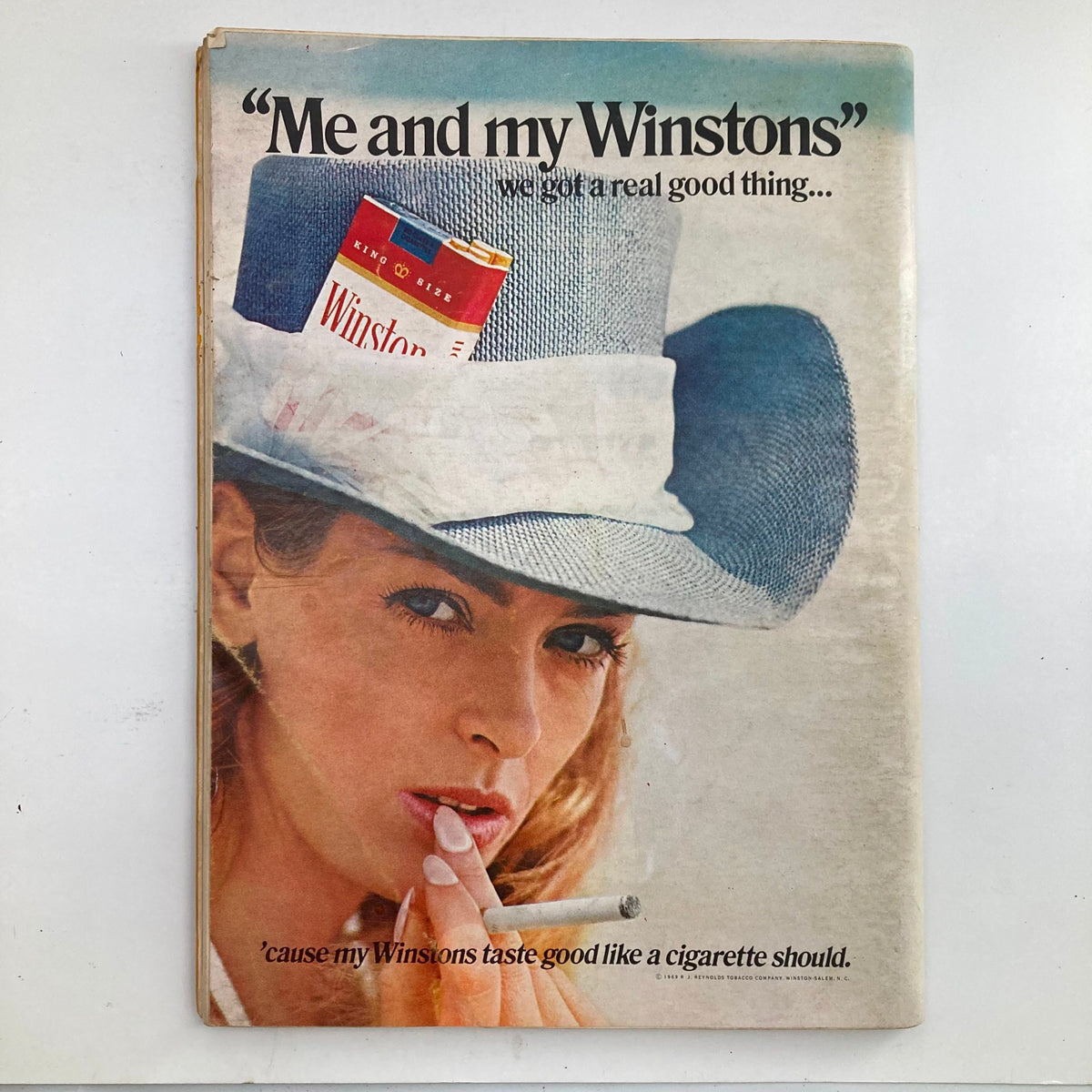 Winston cigarette advertisement featuring a model in a hat, related to the retro theme of the August 1969 Playboy Magazine.