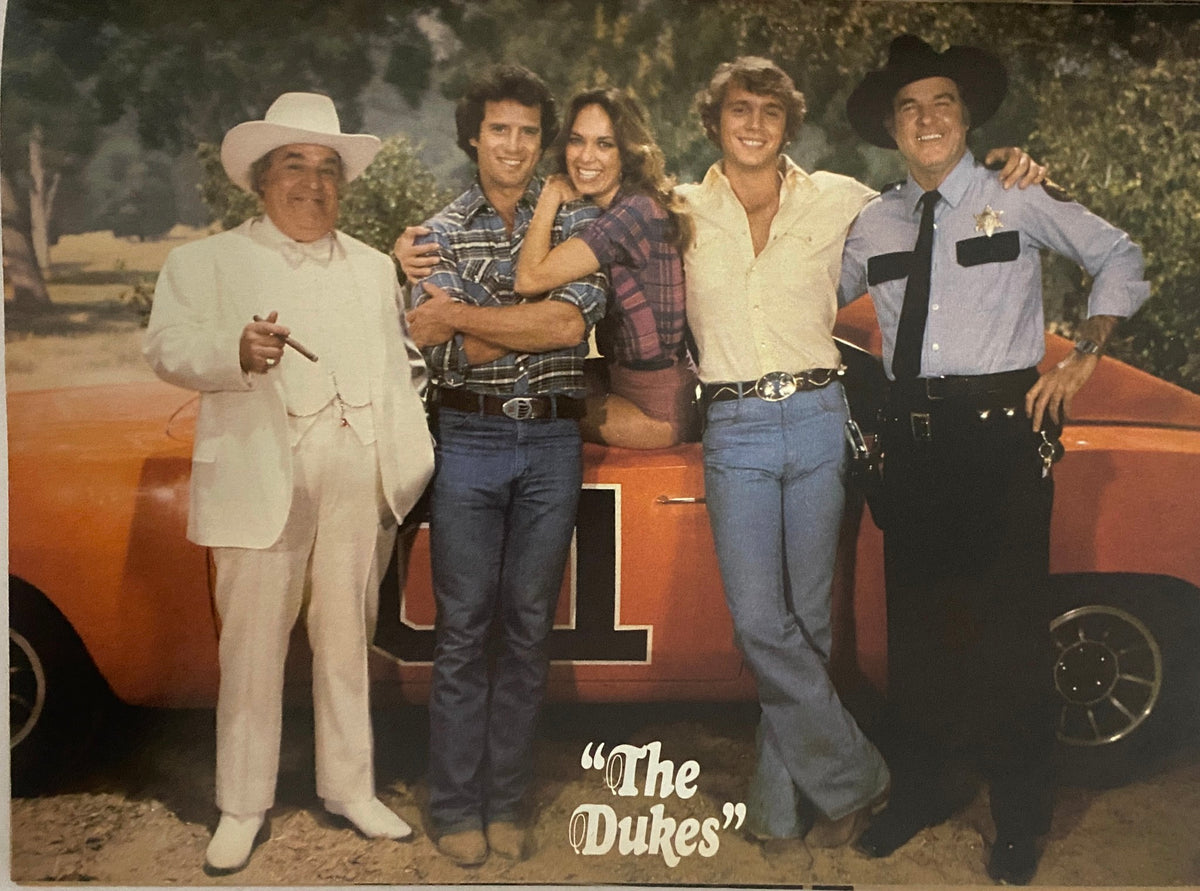 Cast of 'The Dukes of Hazzard' featured in Teen Bag Magazine March 1982, posing together by their iconic car with labeled names for each character.