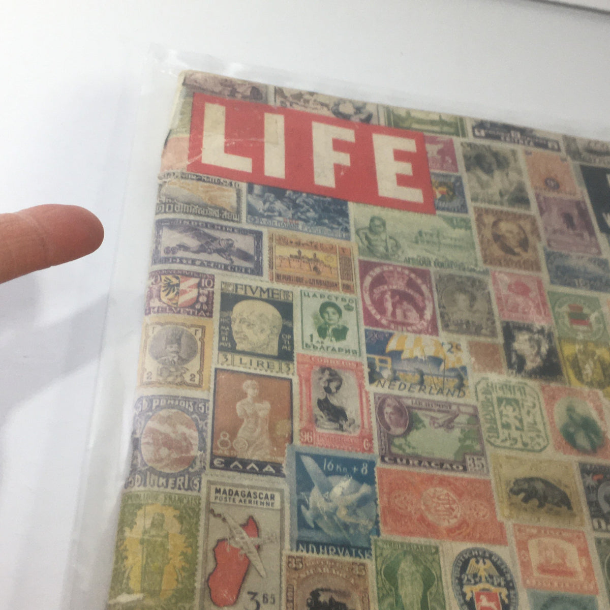 Detailed view of the cover of VTG Life Magazine May 3, 1954, showcasing vintage stamps and the magazine title.