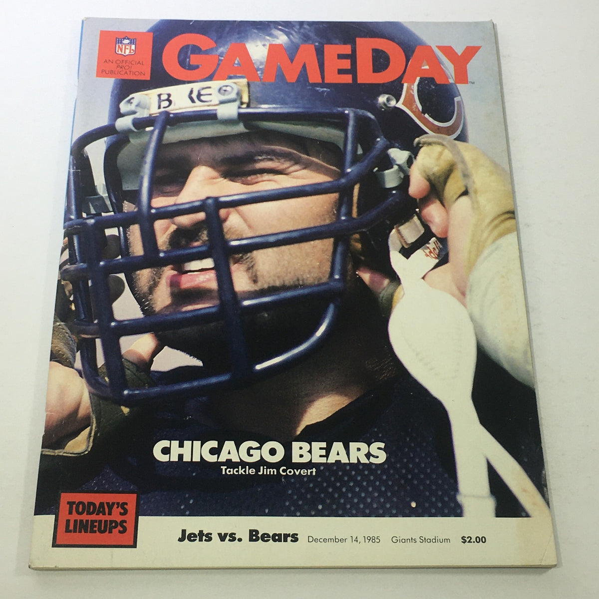 Cover of Gameday NFL Magazine: December 14, 1985, featuring Chicago Bears tackle Jim Covert, showcasing a close-up of the player in his helmet and uniform against the backdrop of the magazine's title and details for the Jets vs. Bears game.
