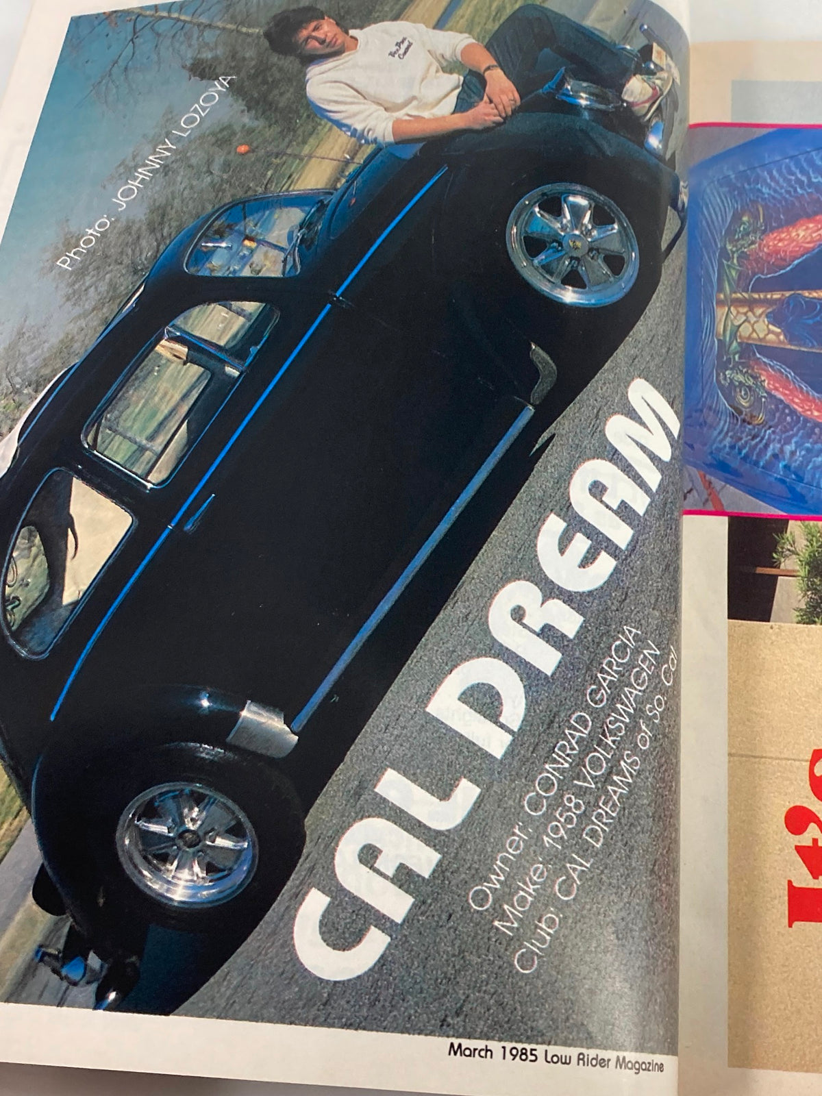 March 1985 Low Rider Magazine featuring 'Cal Dream' car photo with owner Conrad Garcia. Captured by photographer Johnny Lozoya, showcasing lowrider culture.