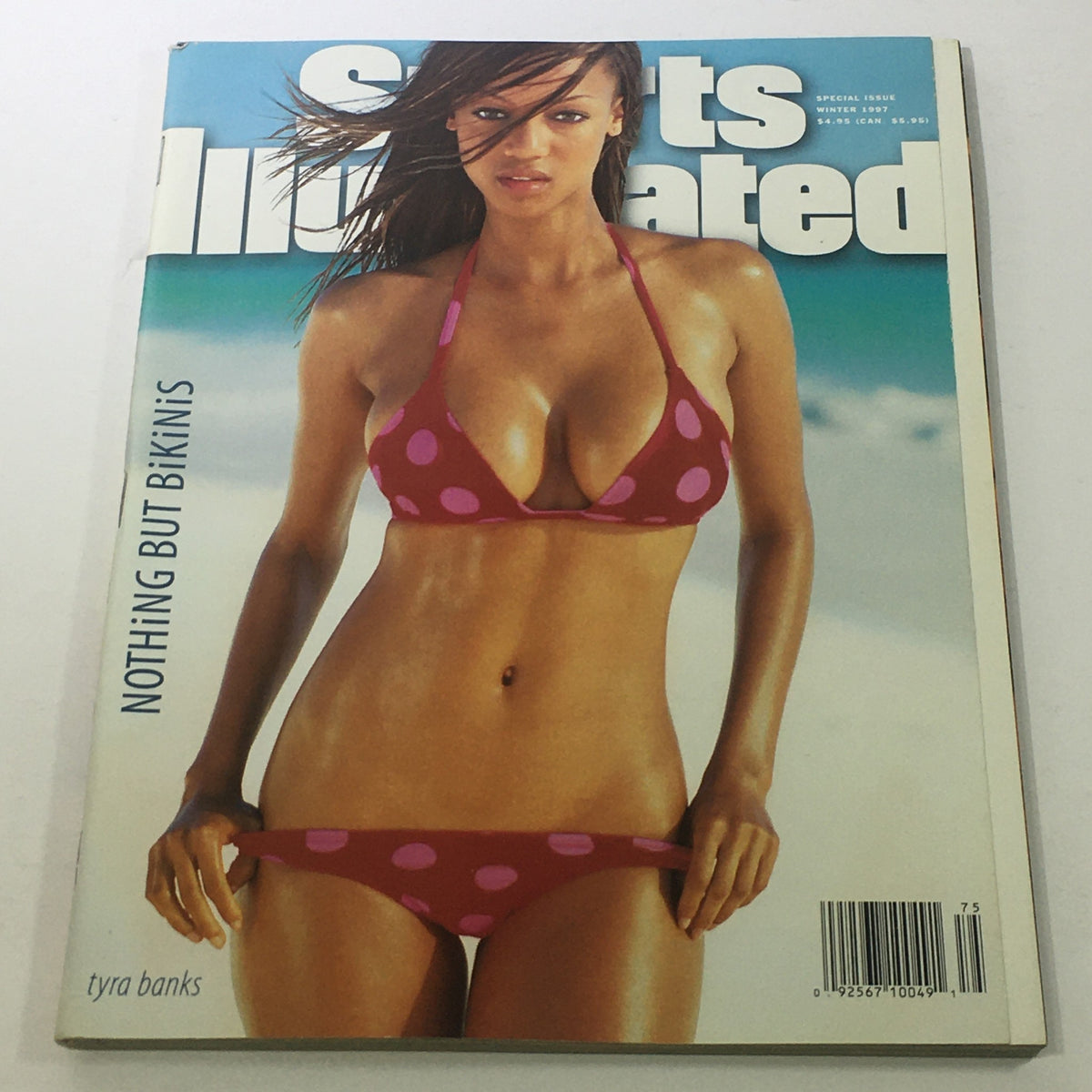 Sports Illustrated Winter 1997 cover featuring Tyra Banks in a red bikini with polka dots, highlighting the bold fashion and beauty of the 1990s.
