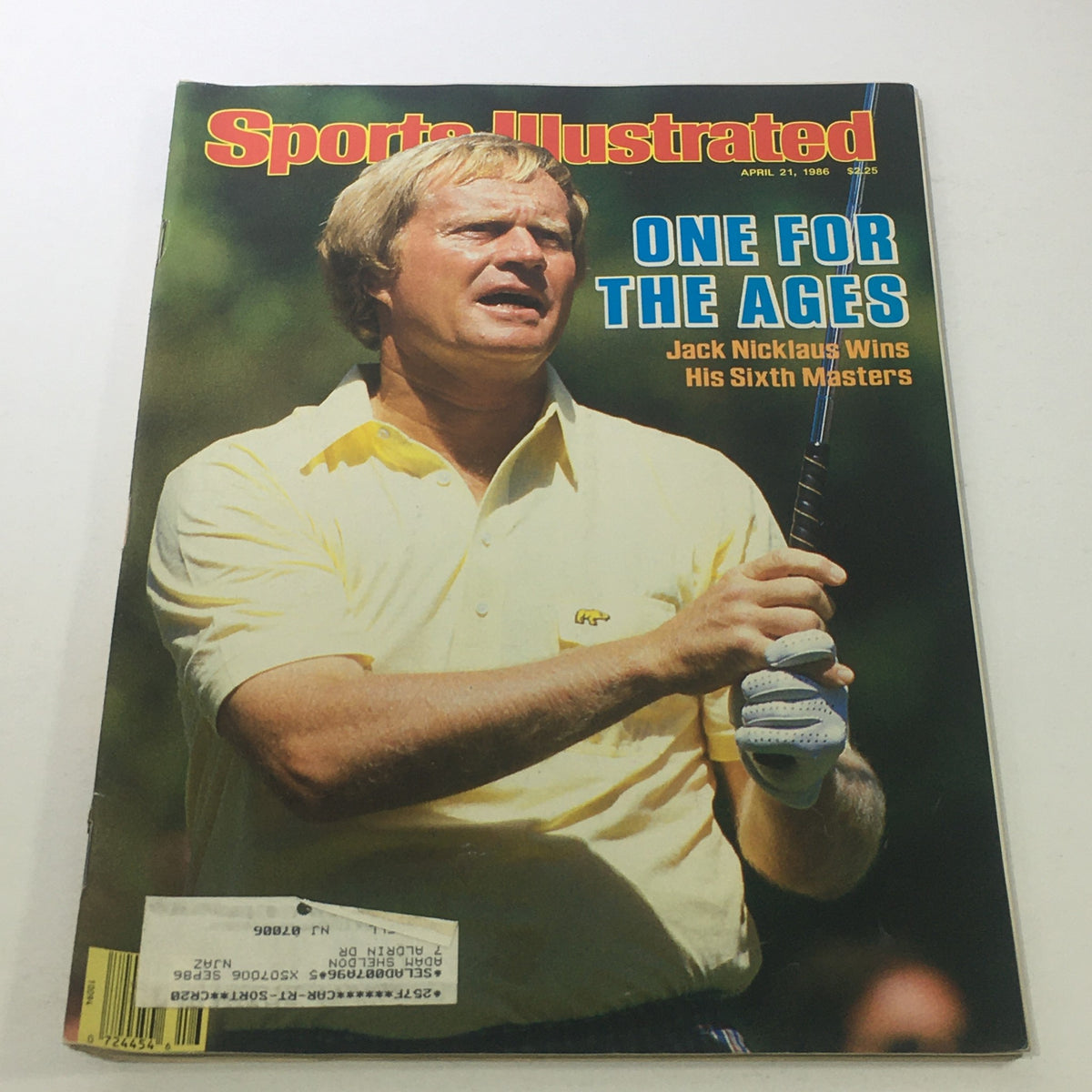 Cover of Sports Illustrated, April 21, 1986, featuring Jack Nicklaus celebrating his sixth Masters victory, wearing a yellow shirt and holding a golf club against a green background.