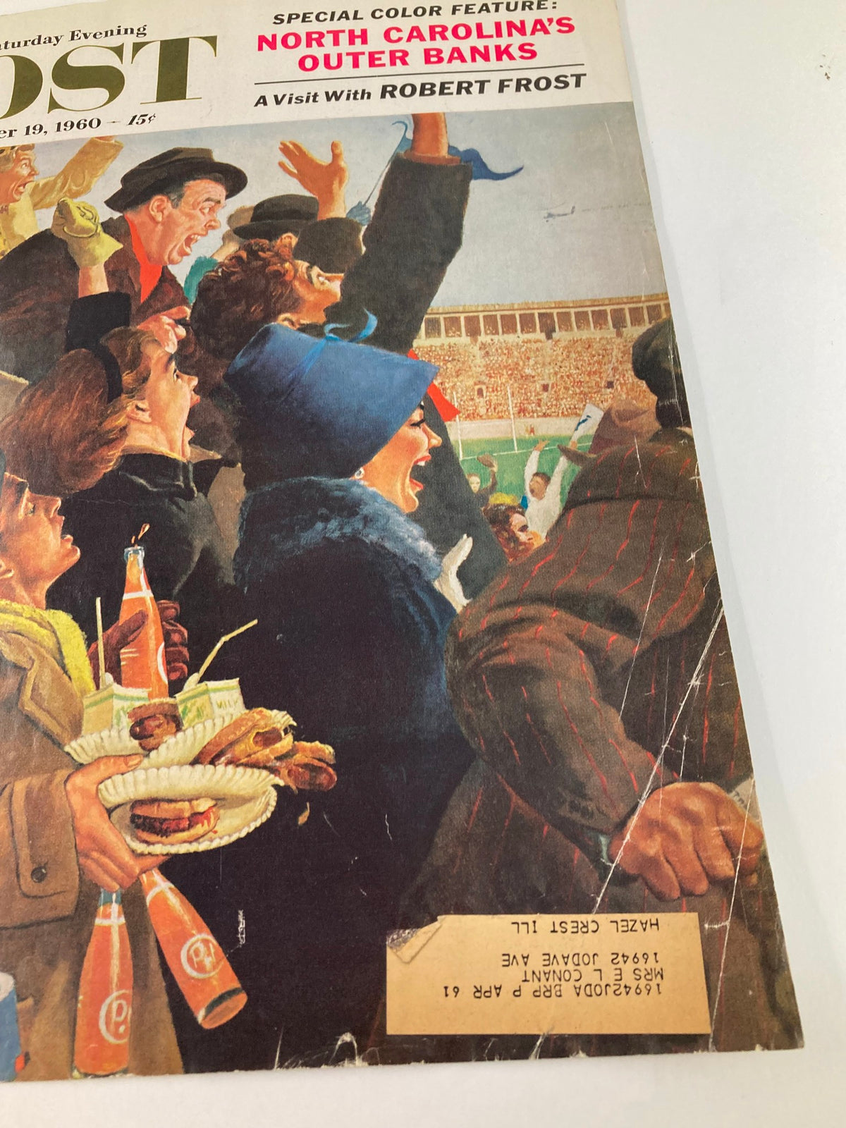 Cover of The Saturday Evening Post from November 19, 1960, featuring a vibrant scene of fans at a sports event, celebrating a visit with Robert Frost.