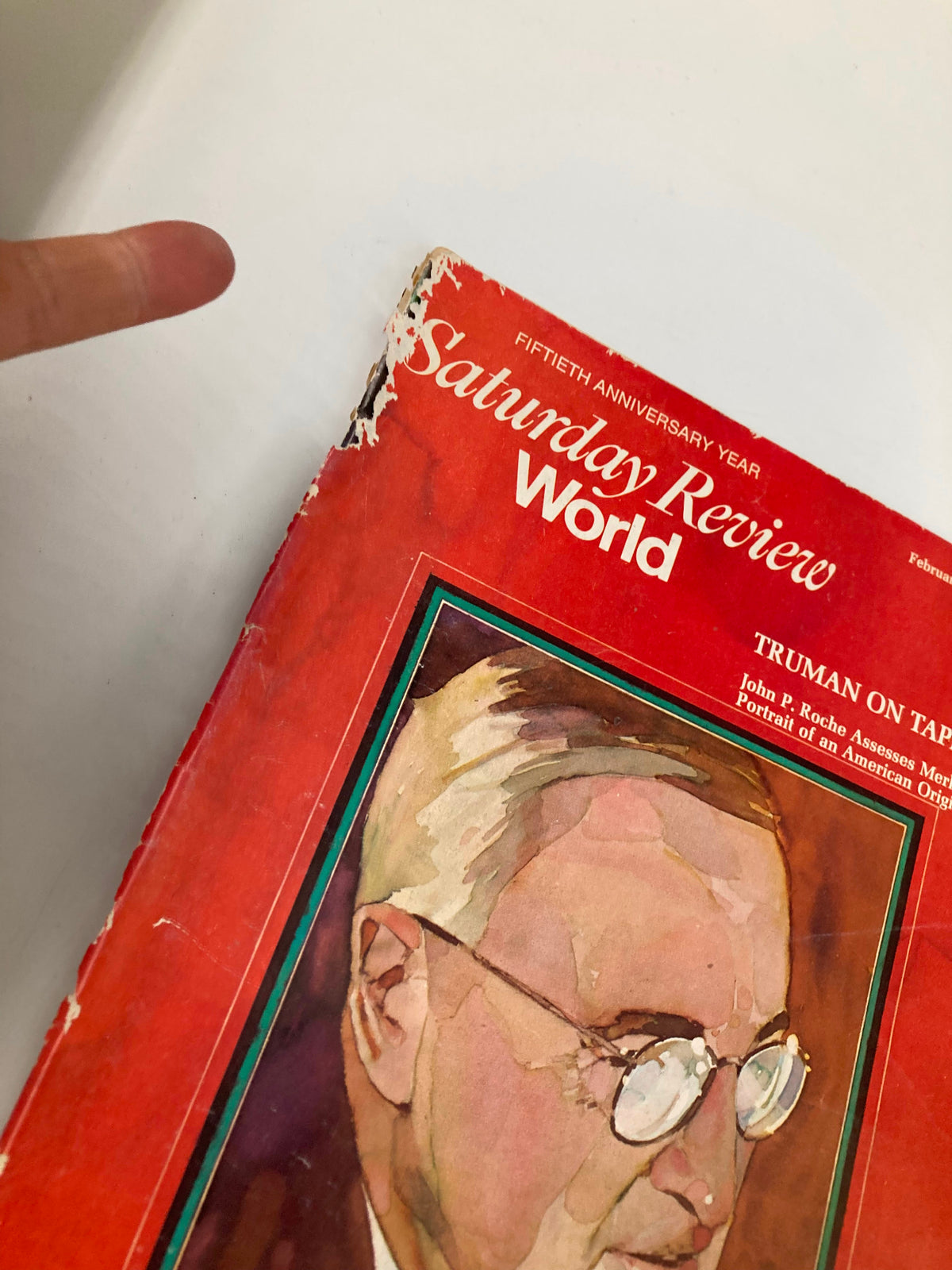 Side view of the February 23, 1974, Saturday Review Magazine titled 'VTG Saturday Review Magazine February 23 1974 Harry S. Truman on Tape,' showcasing the magazine cover with minor wear and a finger pointing to the edges, emphasizing its vintage condition.