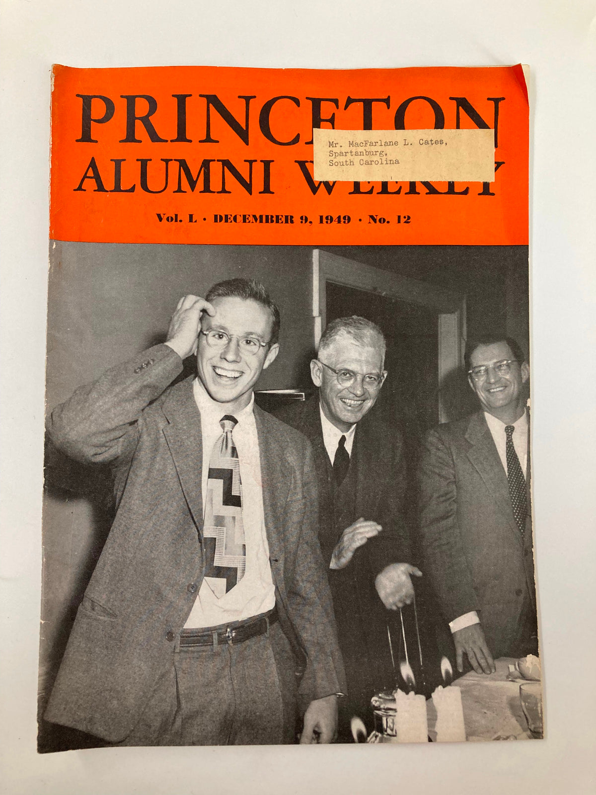 VTG Princeton Alumni Weekly December 9 1949 featuring alumni at a gathering, showcasing the cover with a bright orange design and notable individuals celebrating with candles.