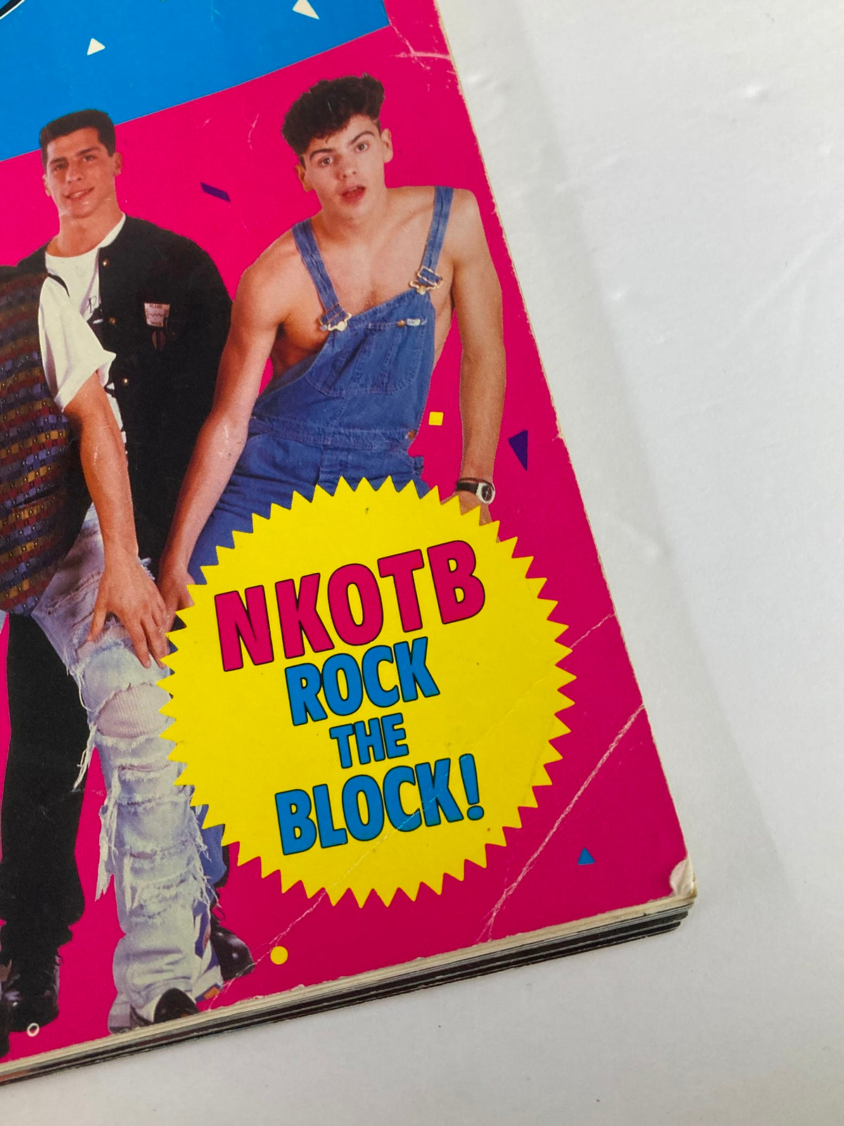 Cover image from '1990 Publications International, Ltd. Presents New Kids On The Block' featuring a colorful design with a young male in overalls. The bold text says 'NKOTB ROCK THE BLOCK!' highlighting the iconic boy band.