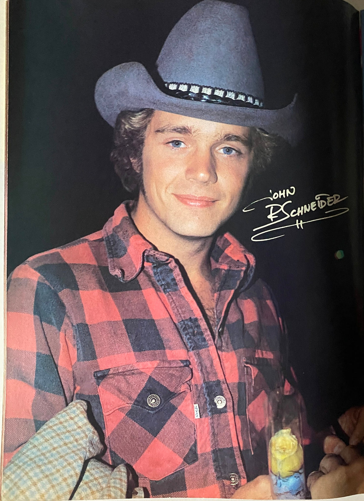 Celebrity portrait of John Schneider from Tiger Beat Magazine May 1982, wearing a cowboy hat and a plaid shirt, signed for fans.
