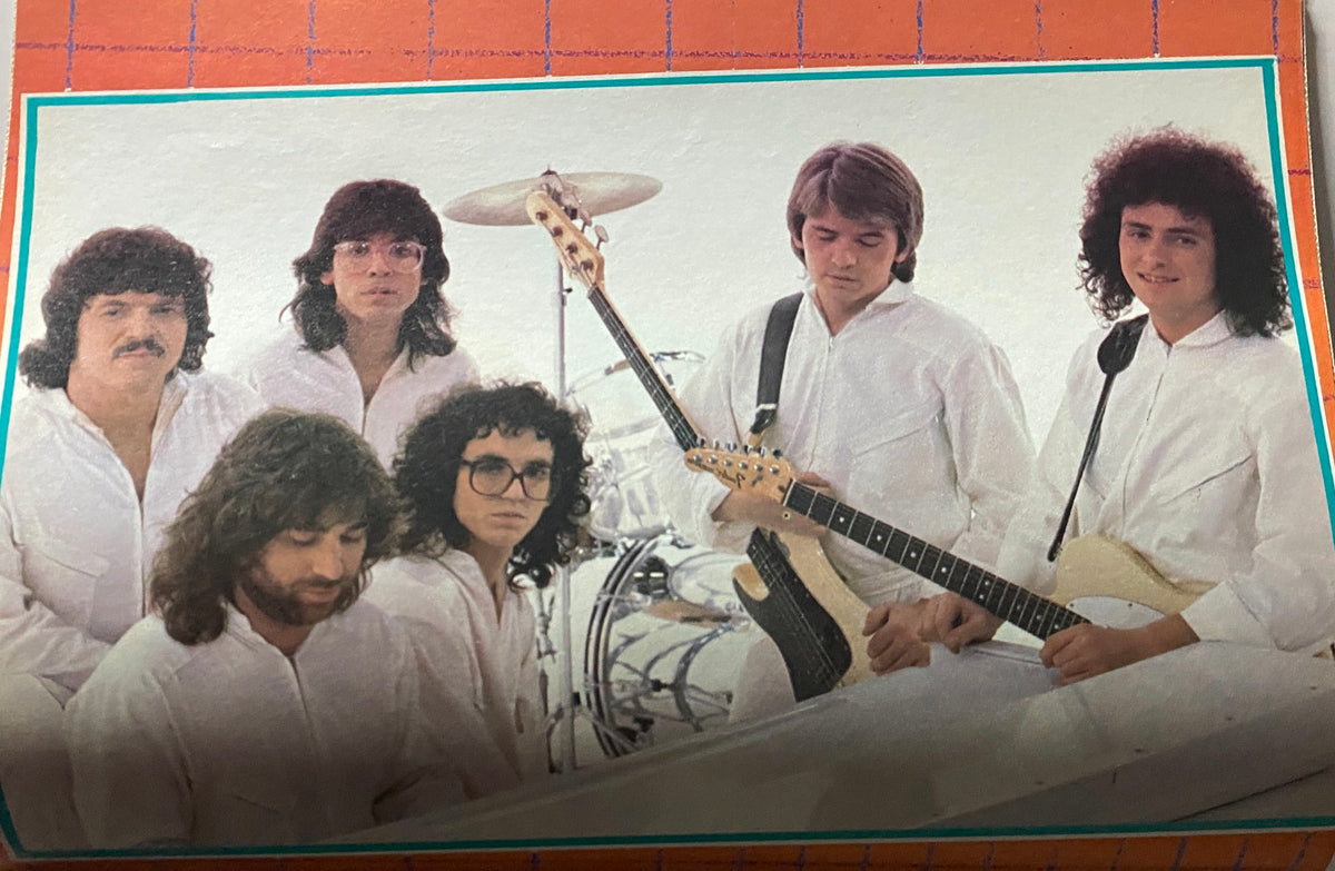 Band performing in the 1980s, featuring members dressed in white, featured in the August 1980 issue of Tiger Beat Magazine. A capturing moment for music enthusiasts and collectors.