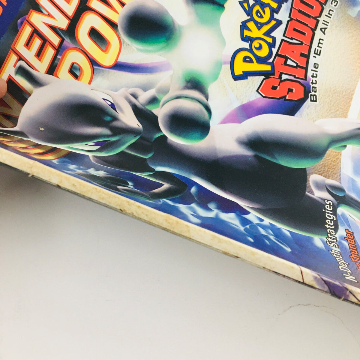 Close-up of the spine of the Nintendo Power Magazine March 2000 Vol 130 featuring Pokémon Stadium Battle 'Em All in 3D with artwork of Mewtwo.