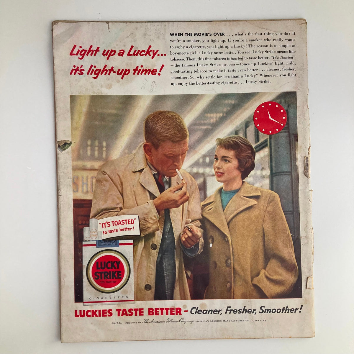 Vintage advertisement from Look Magazine April 5, 1955, featuring a man lighting a Lucky Strike cigarette, alongside a woman, emphasizing the tagline 'Luckies Taste Better - Cleaner, Fresher, Smoother!' This ad reflects the culturally significant views on smoking in the 1950s.