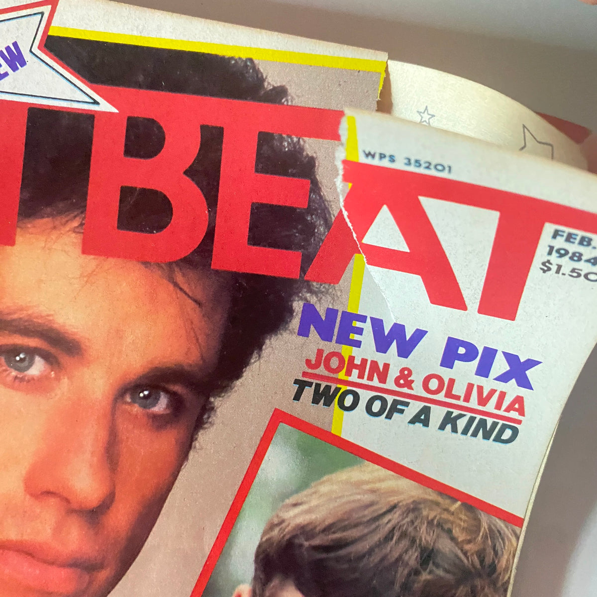 Close-up of the Teen Beat Magazine February 1984 cover showing John Travolta and Olivia Newton-John with the 'New Pix' and 'Two of a Kind' announcement.