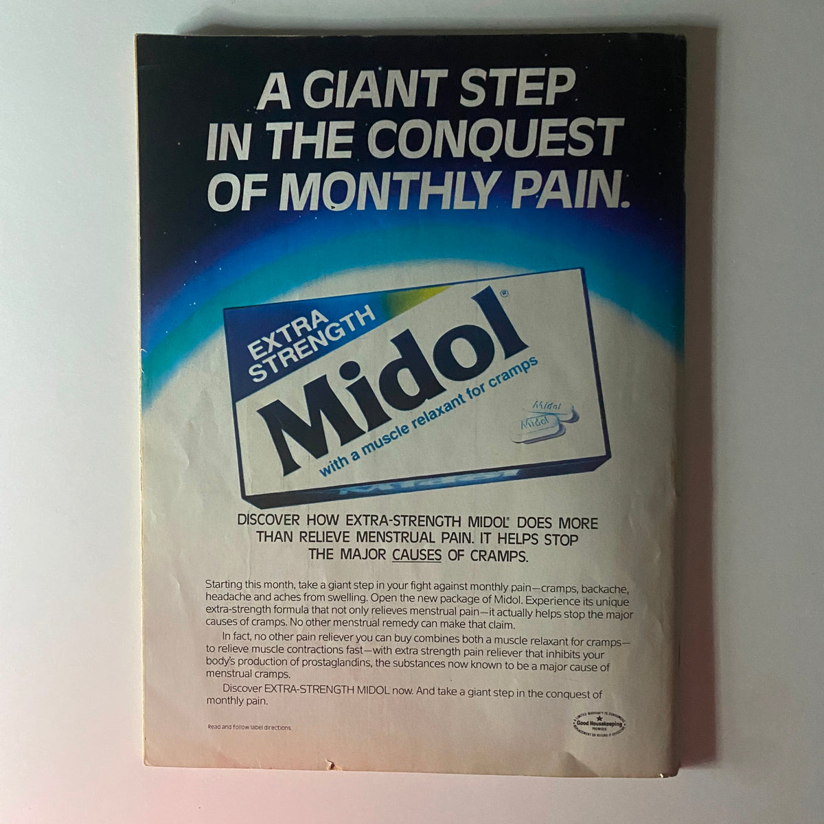 A vintage advertisement for Extra Strength Midol, featuring the tagline 'A Giant Step in the Conquest of Monthly Pain.' The ad highlights Reducing menstrual cramps and offers a description of the product's efficacy. Related to the Teen Beat Magazine February 1984 John Travolta, Olivia Newton-John with Poster.