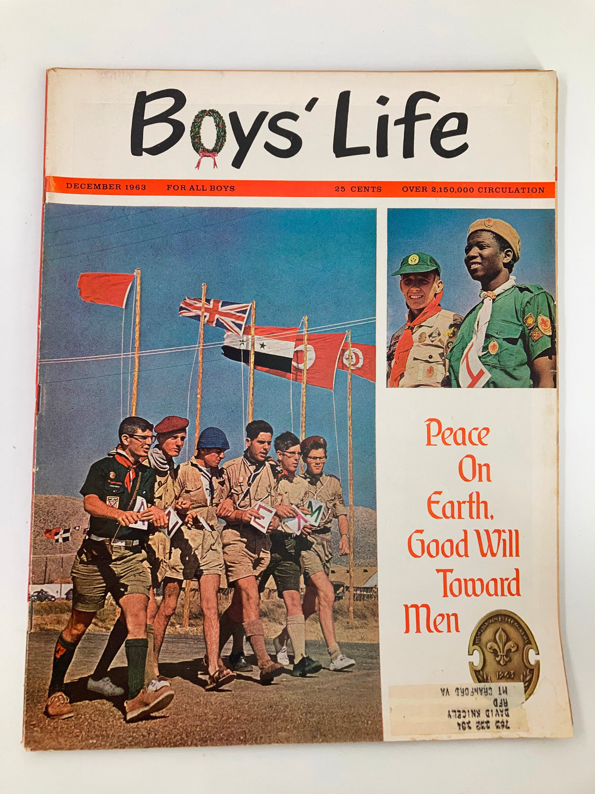 Cover of Boys' Life Magazine December 1963 titled 'Peace On Earth, Good Will Toward Men', featuring boys in scout uniforms and flags. A vibrant depiction of holiday spirit and camaraderie.
