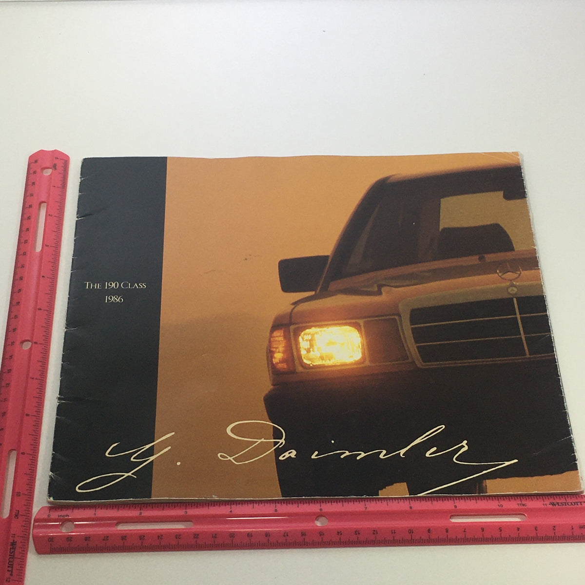 Front cover of the 1986 Mercedes-Benz 190 Class Dealership Car Auto Brochure Catalog, showcasing the 190 Class vehicle with a design and Daimler signature.