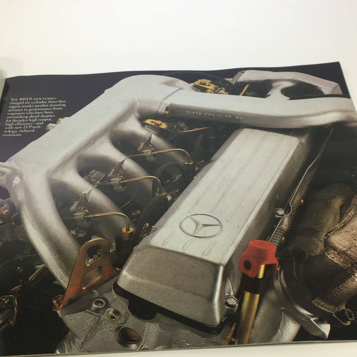 Detailed image of the engine of the 1986 Mercedes-Benz 300 Class from the auto brochure catalog, displaying engineering dedication and innovation.