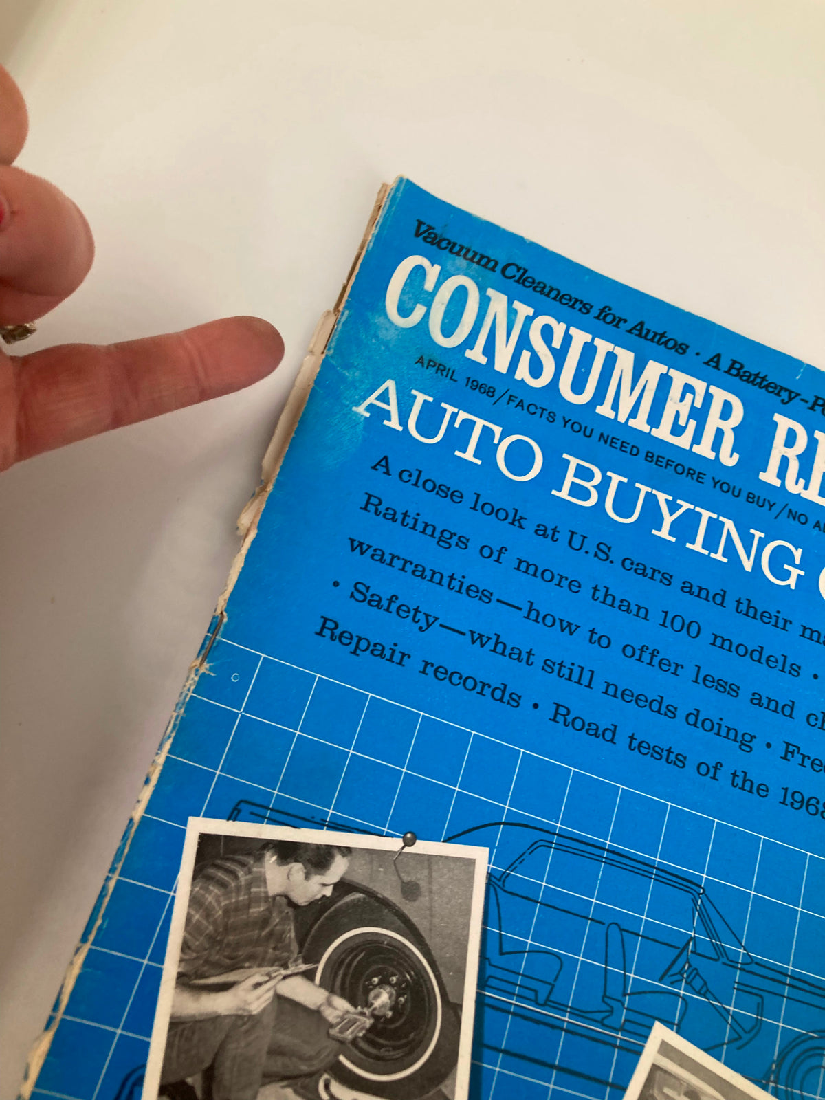 Close-up of the cover of the VTG Consumer Reports Magazine April 1968, highlighting the title 'AUTO BUYING GUIDE'. The image shows the edge of the magazine with a focus on the text and images of car maintenance and a vintage automobile.