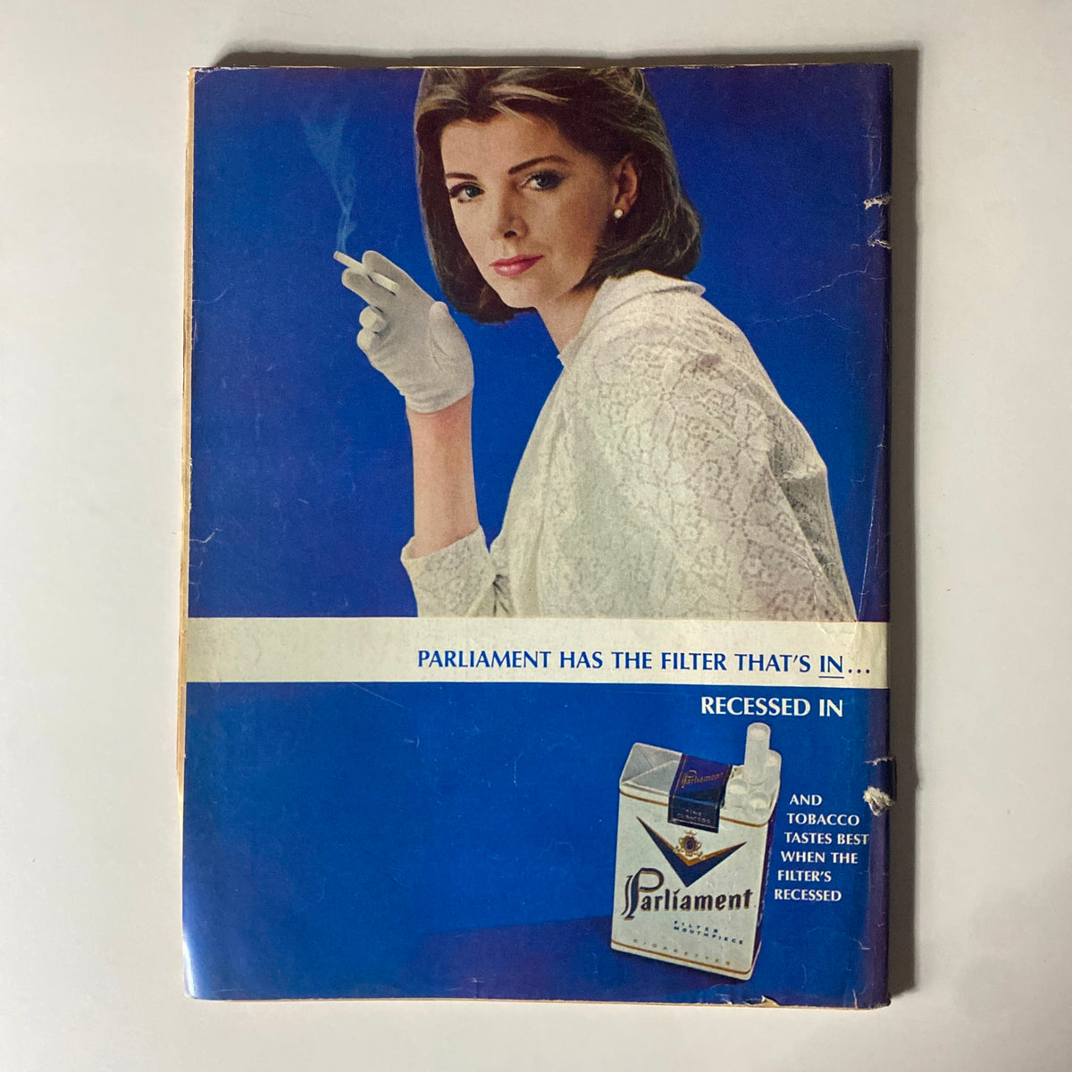 Vintage advertisement featuring a woman in a white outfit holding a cigarette, promoting Parliament cigarettes with the tagline 'Parliament has the filter that's in...,' from the Time Magazine dated November 26, 1965, Vol 86 No. 22.