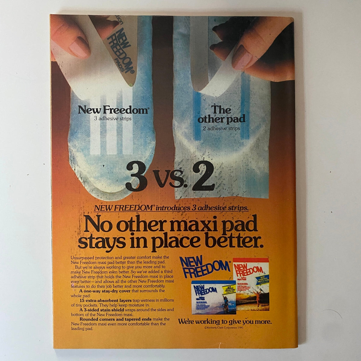 Advertisement for New Freedom maxi pads, emphasizing superior adhesive design for better comfort and reliability.