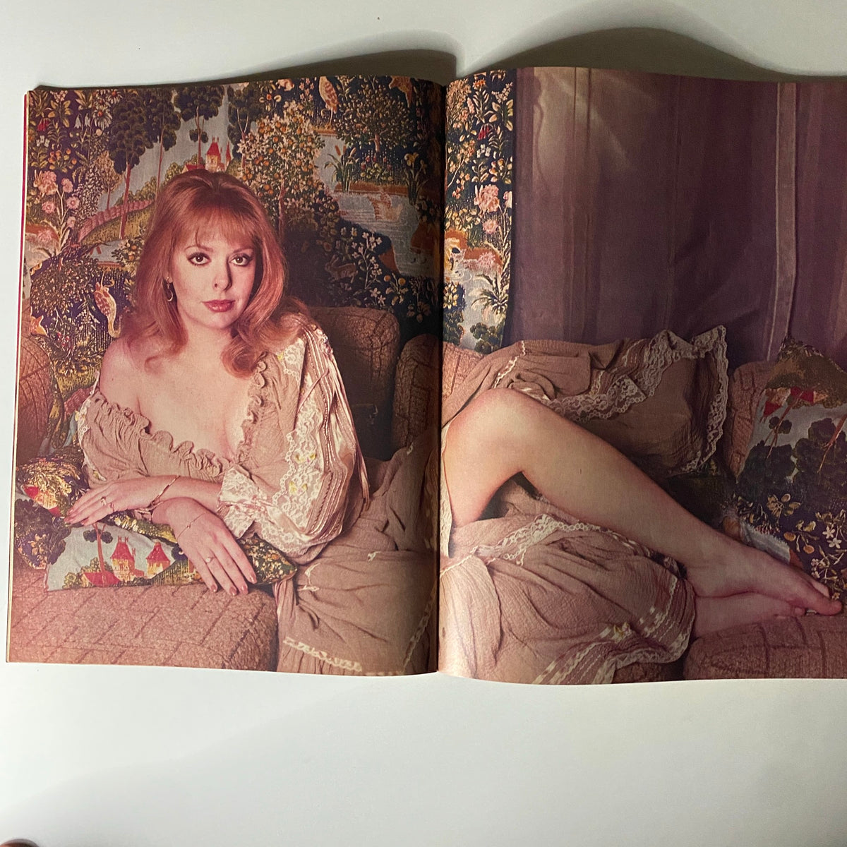 A striking portrait of a red-haired actress relaxing on a couch in a vintage setting from the Photoplay Soaperstar Magazine Summer 1982.