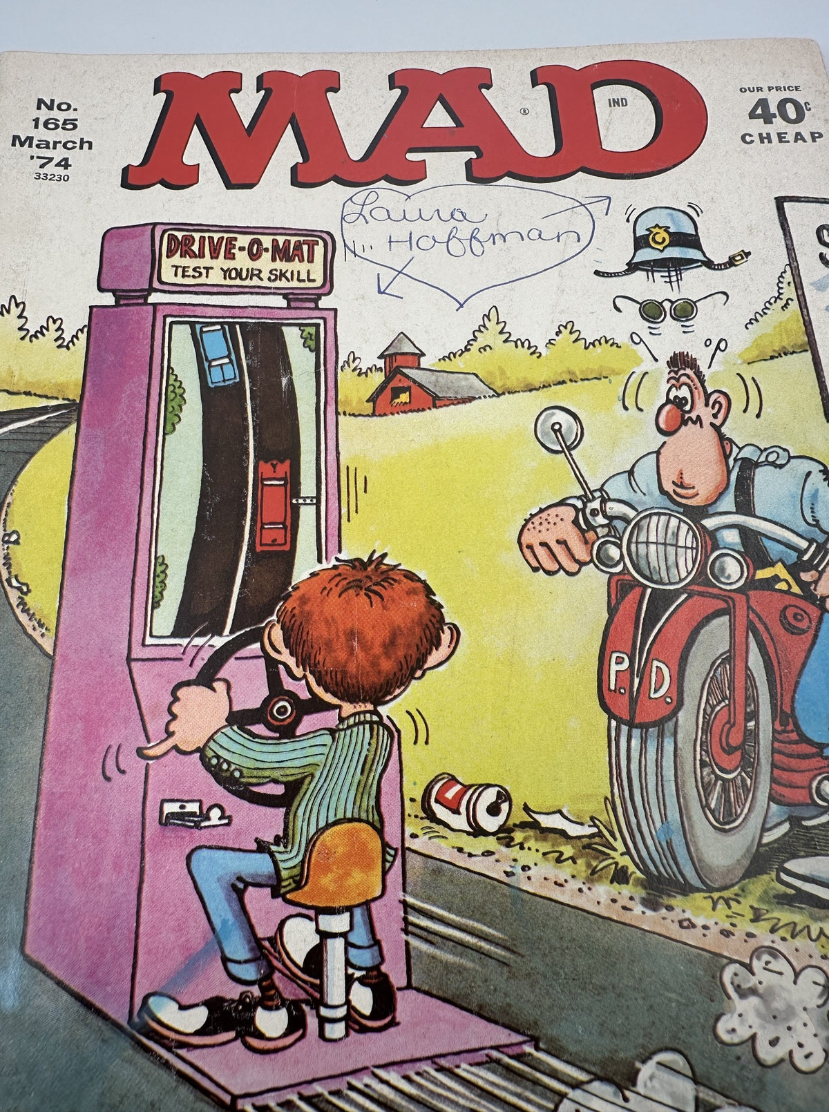 Close-up view of the cover of MAD Magazine No. 165 March 1974, highlighting the 'Drive-O-Mat' game where a boy tests his skill, with playful artwork and a police officer in the background.