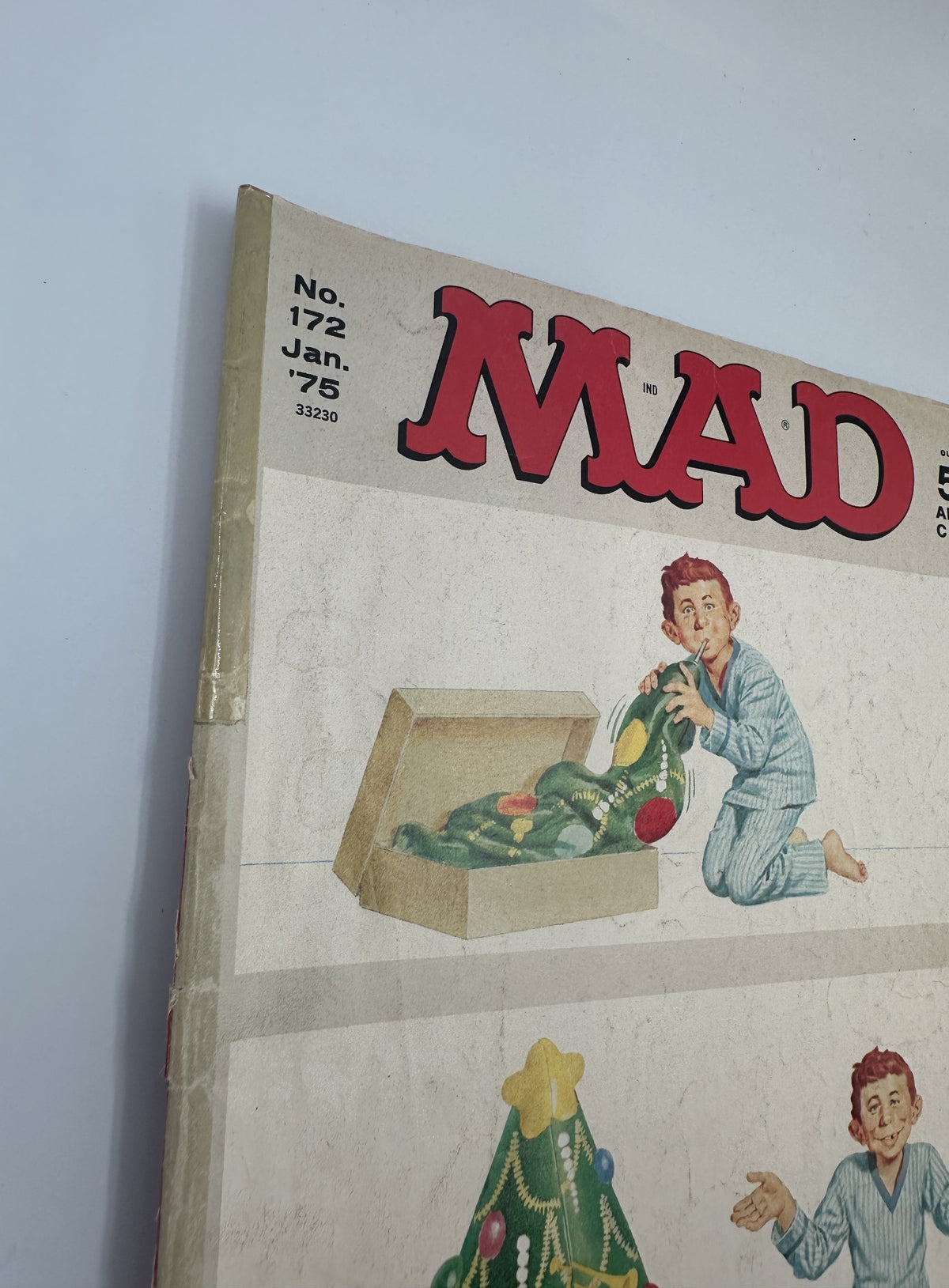 Cover of MAD Magazine No. 172, January 1975, featuring a young boy playing with a Christmas tree while in pajamas. Condition shows significant wear, with spine creases and discoloration.