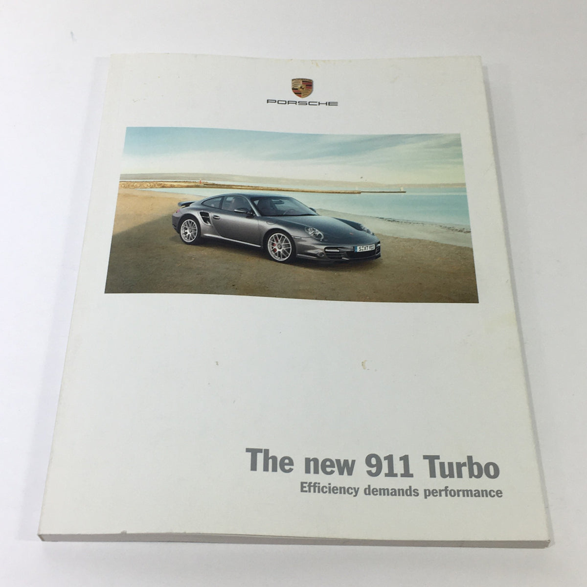 2009 Porsche 911 Turbo Dealership Car Auto Brochure Catalog cover image featuring the Porsche 911 Turbo on a beach.
